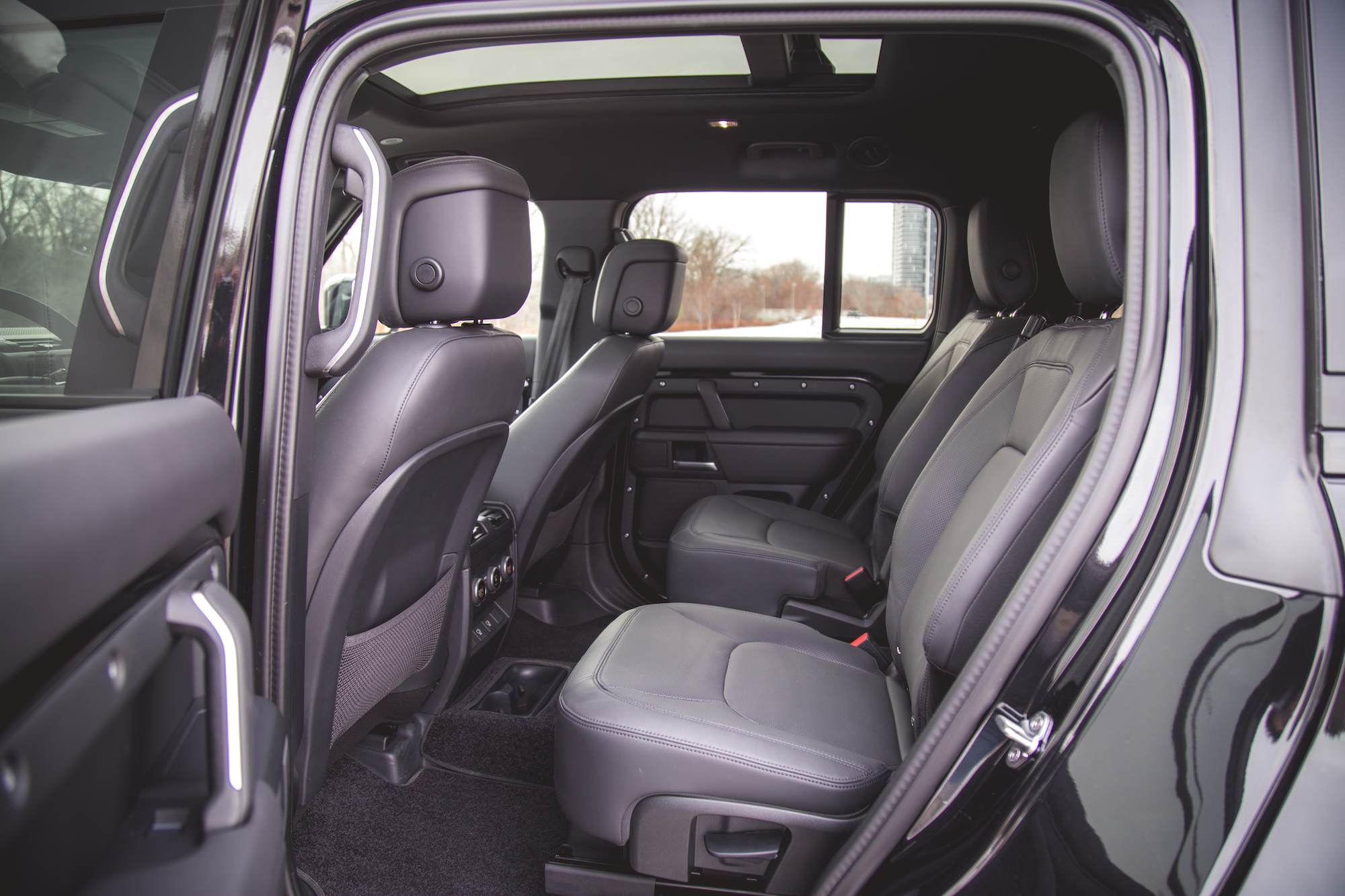 Interior view of the back seating area in a 2026 Land Rover Defender 130, featuring leather seats and ample headroom.