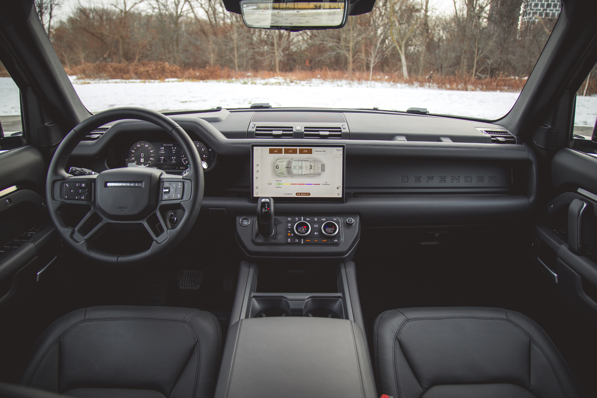Interior view of a 2026 Land Rover Defender 130 showcasing the steering wheel, central touchscreen display, and leather seats.
