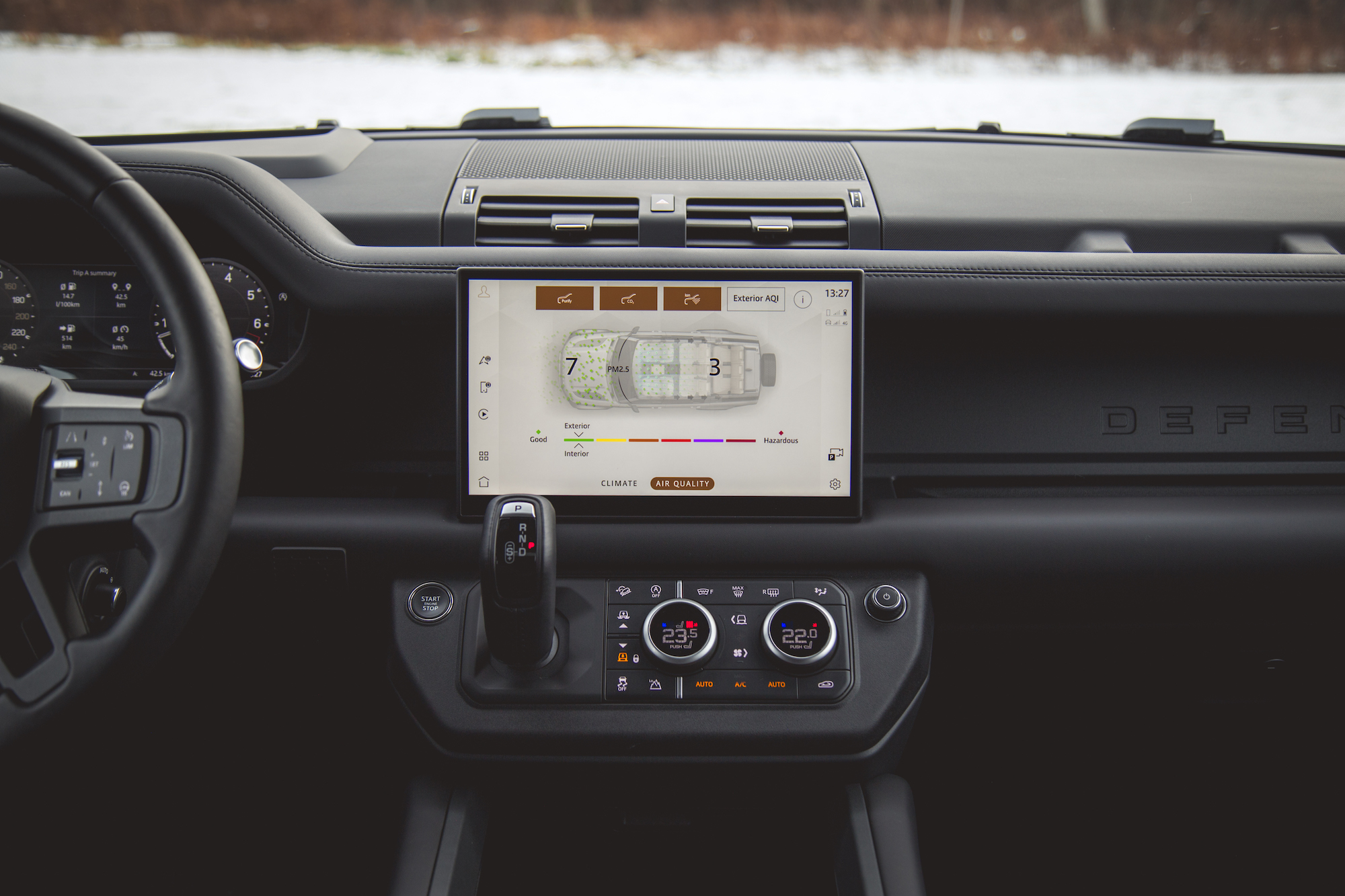 Interior dashboard of a 2026 Land Rover Defender 130, featuring a digital display for climate control and air quality monitor, with modern design elements.