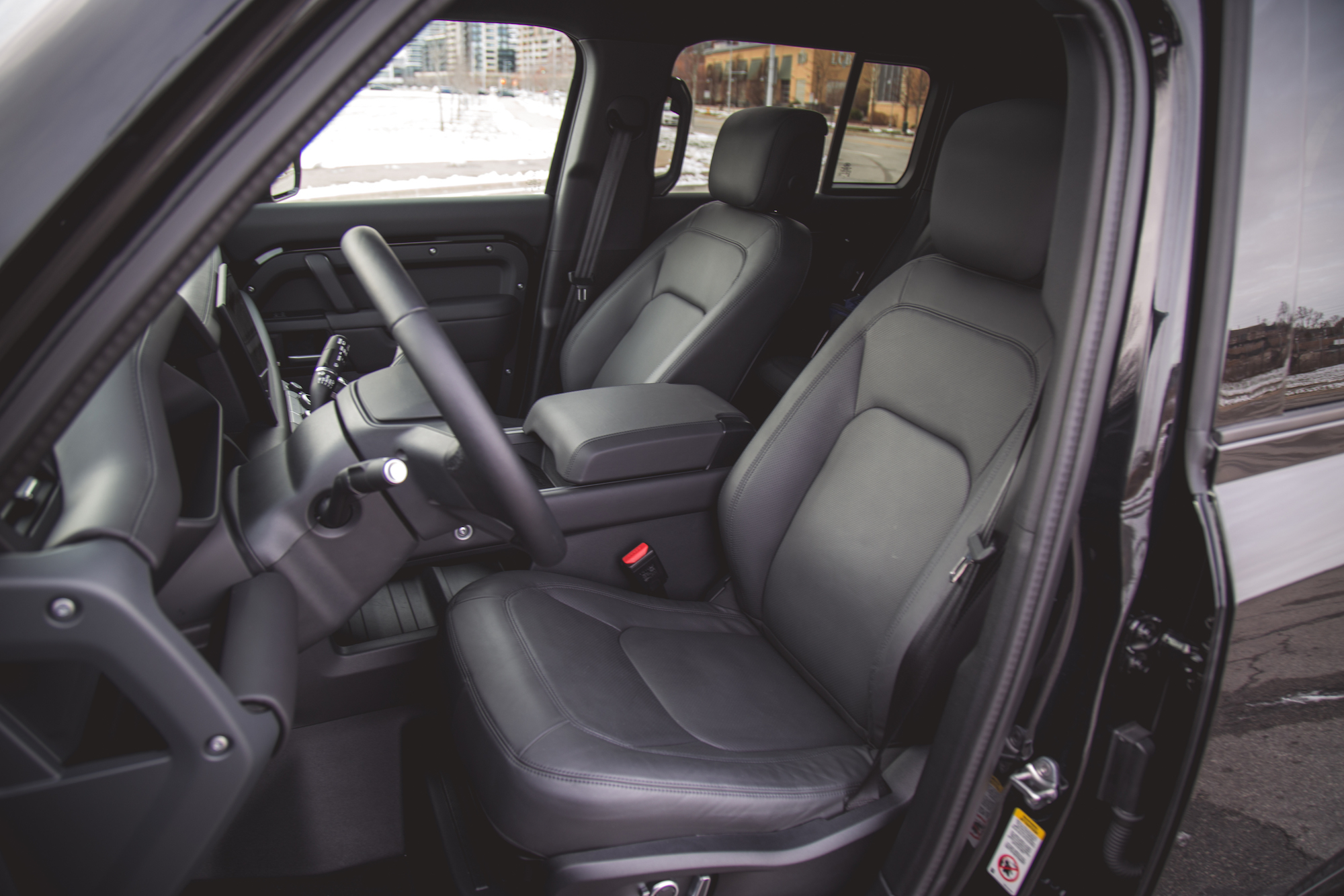 Interior view of a 2026 Land Rover Defender 130 P400 X-Dynamic SE, showcasing black leather seats and a modern dashboard layout.