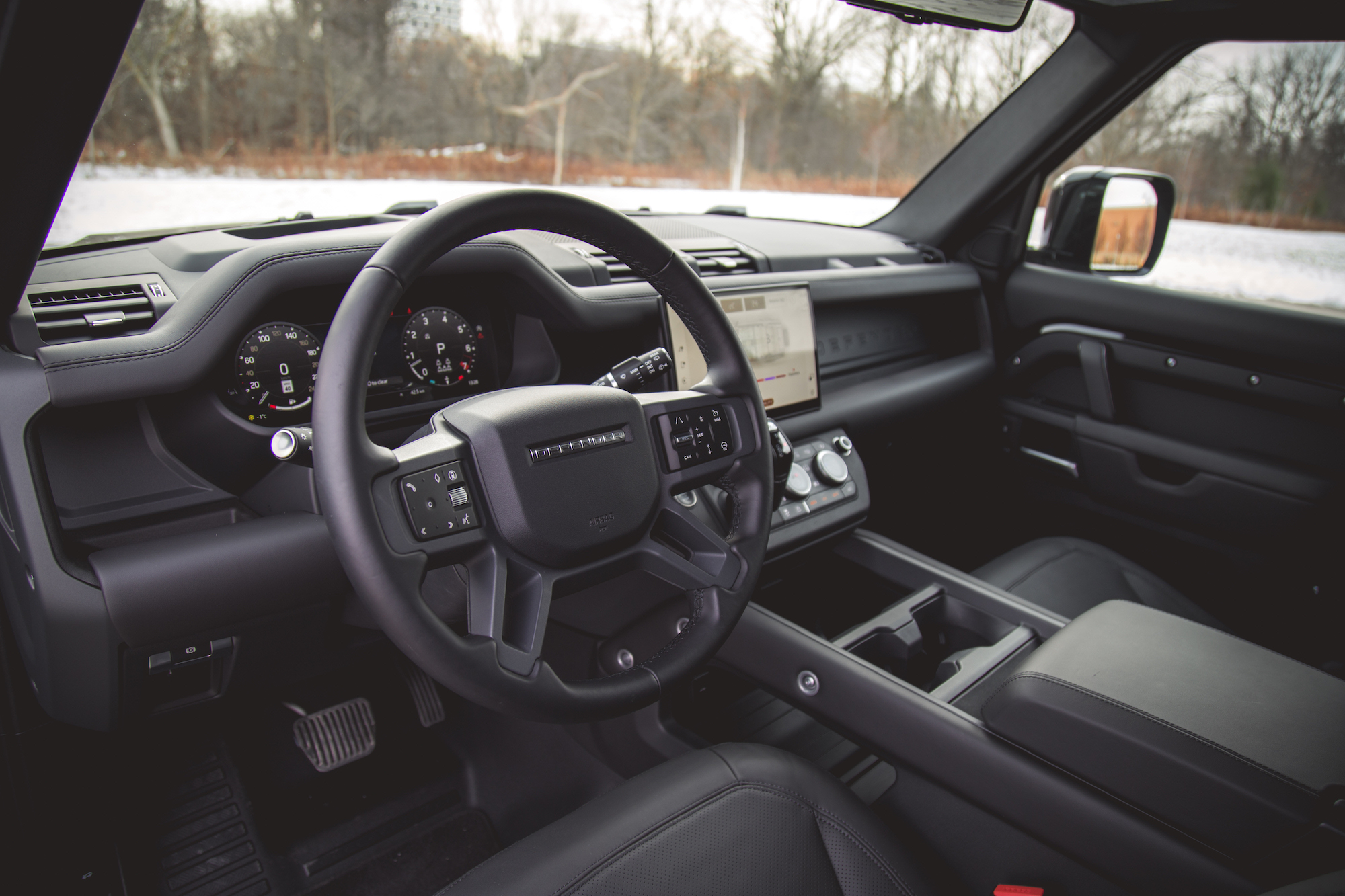 Interior view of a 2026 Land Rover Defender 130 showcasing the steering wheel, dashboard with digital displays, and center console.
