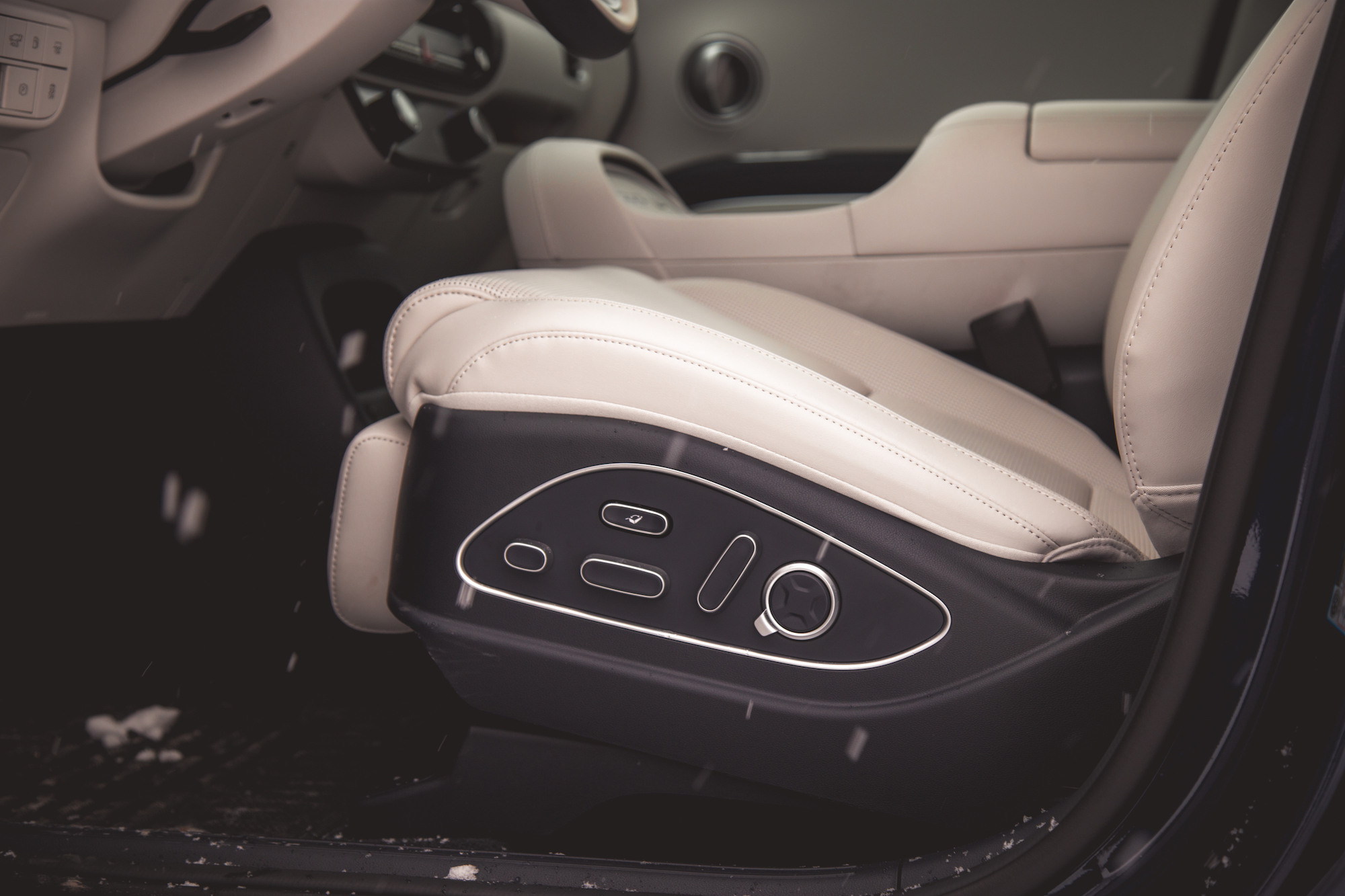 Primer plano del asiento del conductor de cuero de un automóvil con controles ajustables en el costado.