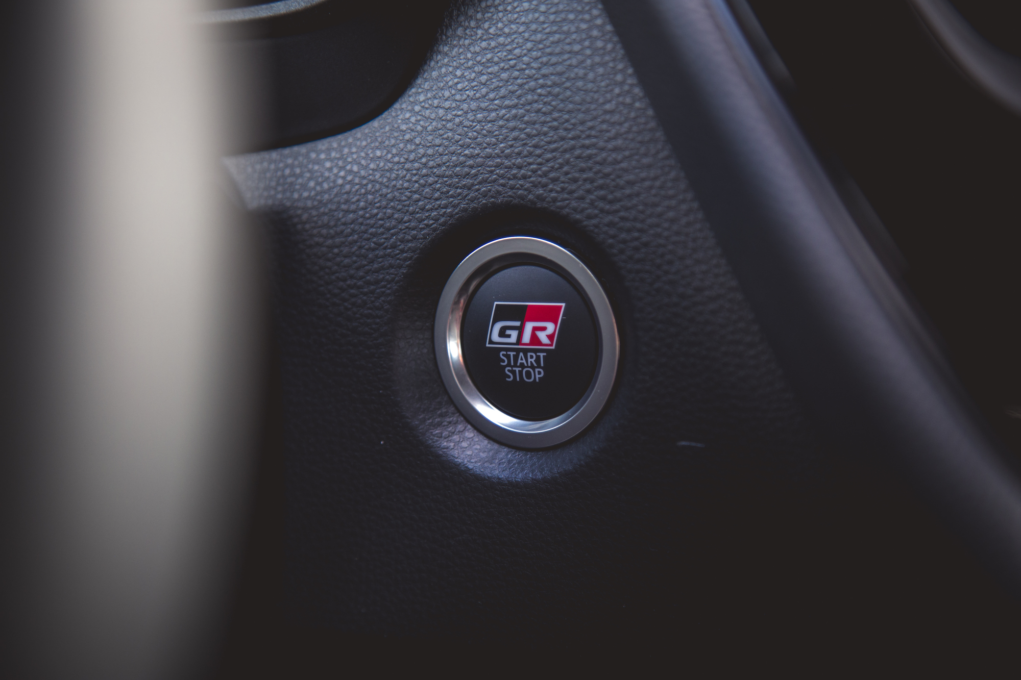 Primer plano de un botón de arranque en el tablero de un automóvil, con el logotipo 