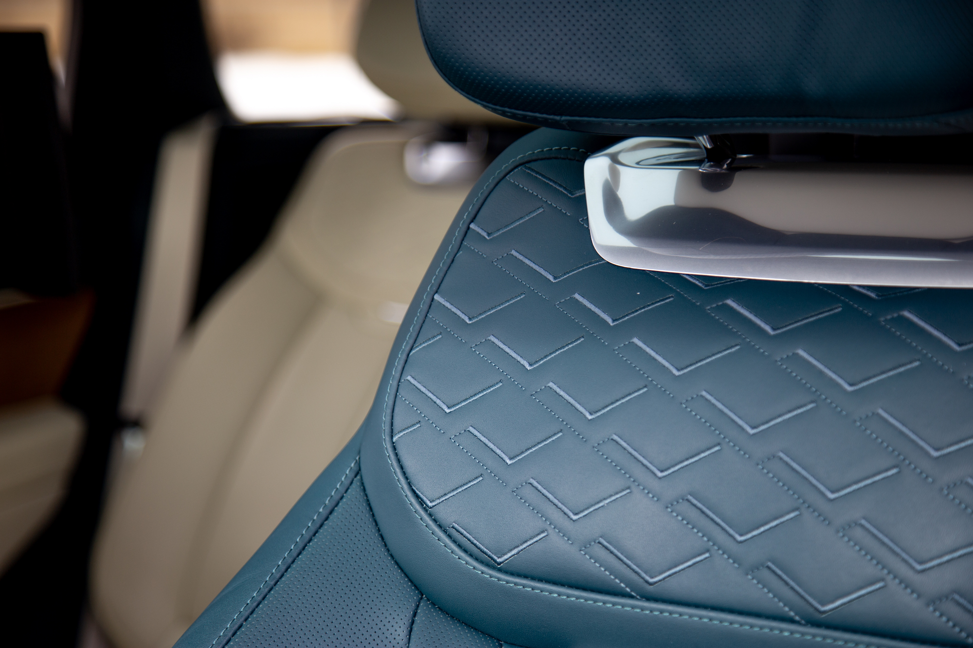 Primer plano de un asiento de automóvil con tapicería de cuero azul texturizado con un patrón en zigzag.