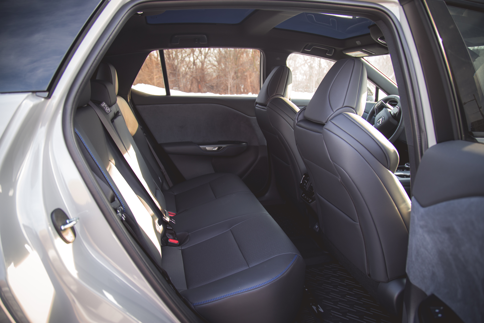 Interior view of a car's back seat with two spacious seats, seat belts visible, and a modern design.