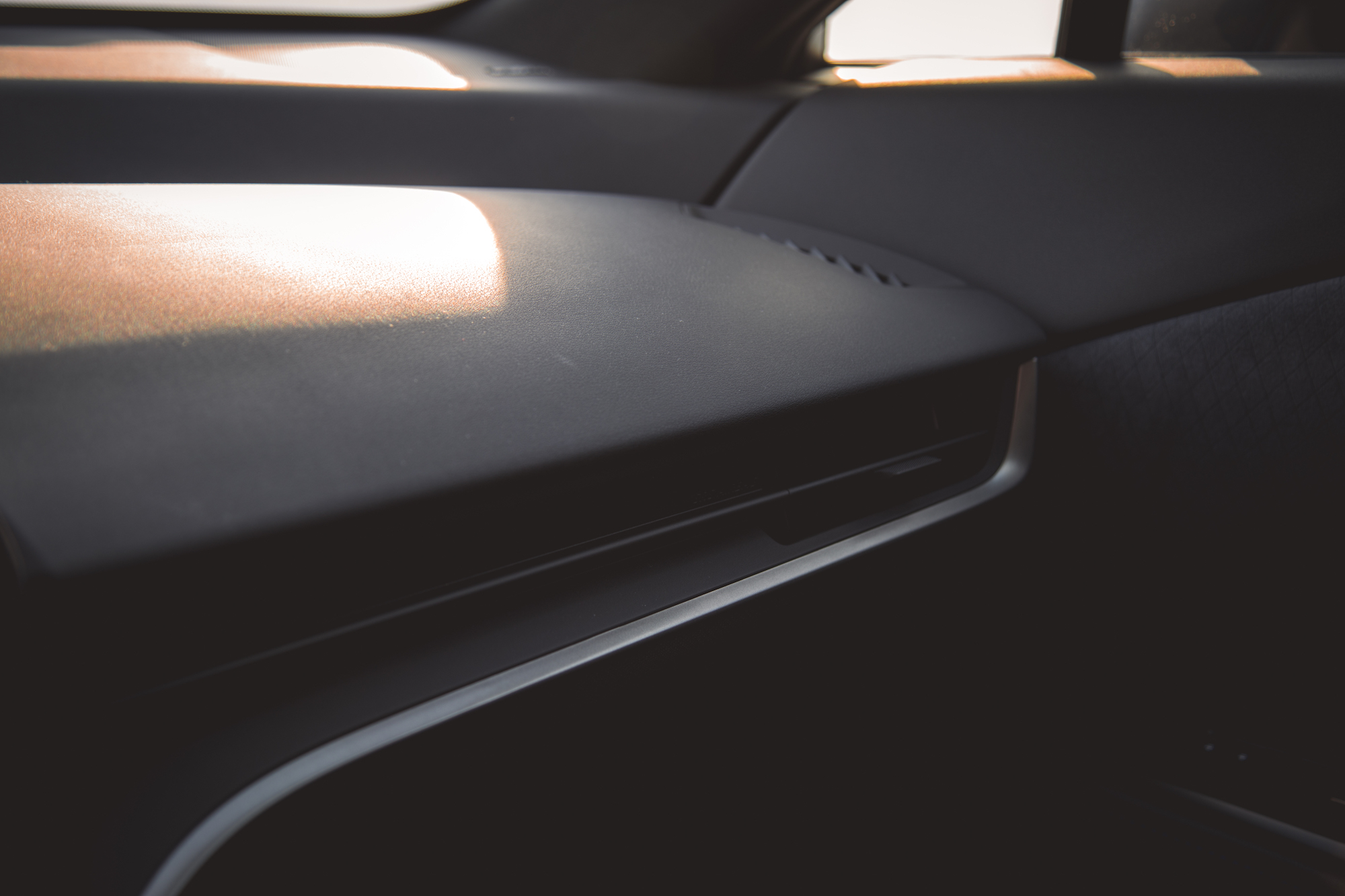 Interior shot of a car dashboard with soft lighting and textured surfaces.