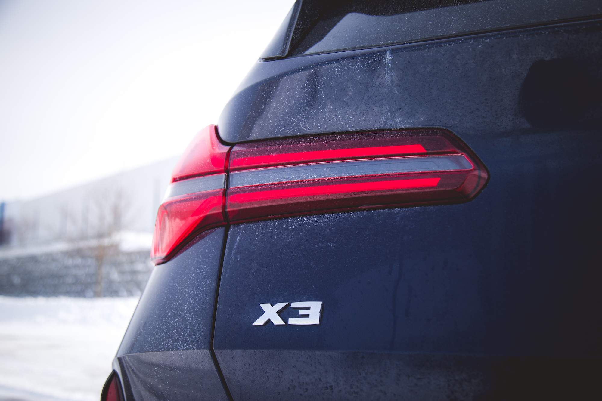Close-up of the rear of a BMW X3, highlighting the taillight and the X3 badge.