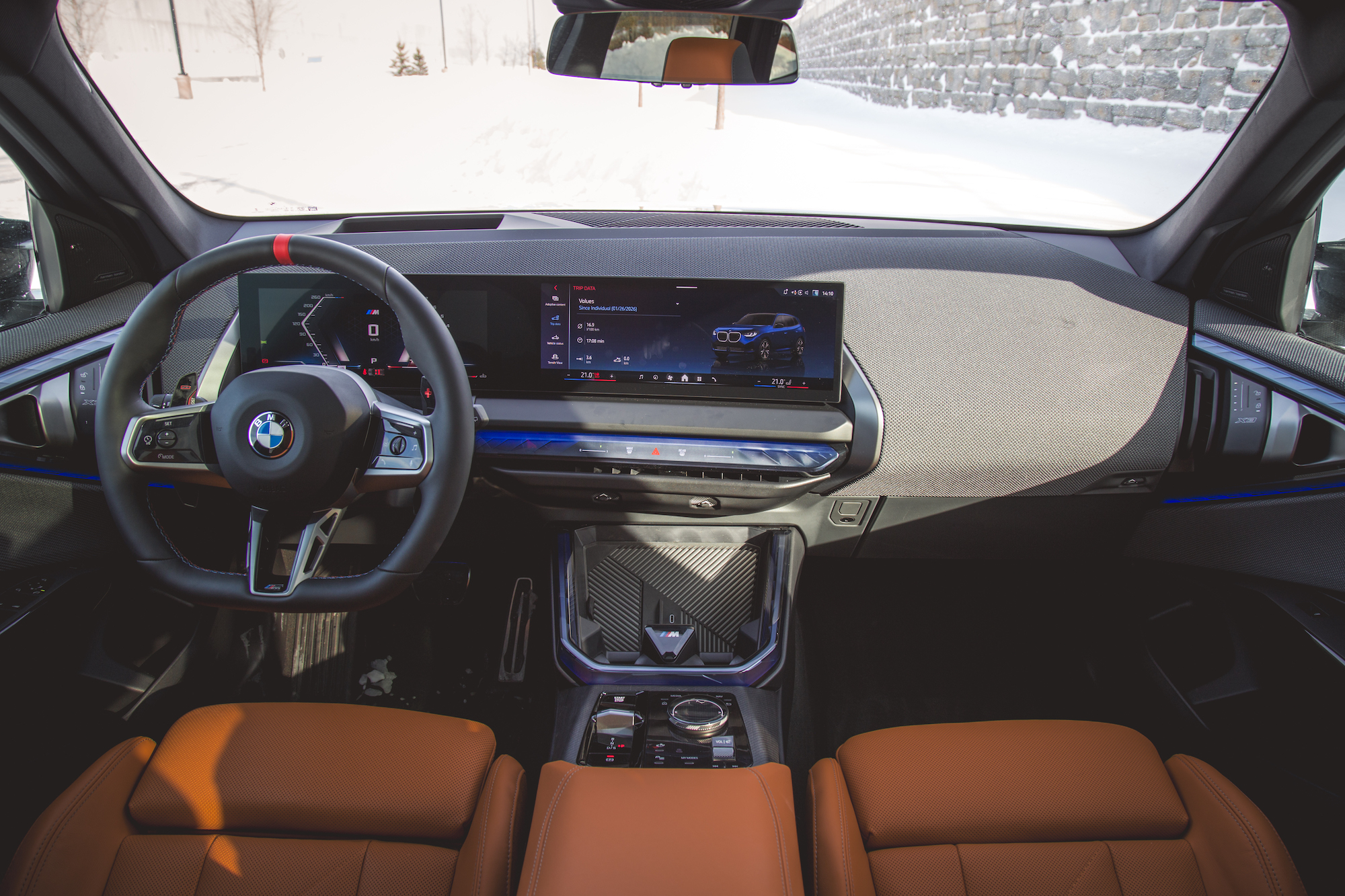Interior view of a BMW car showcasing a modern dashboard with a digital display, steering wheel, and leather seats.
