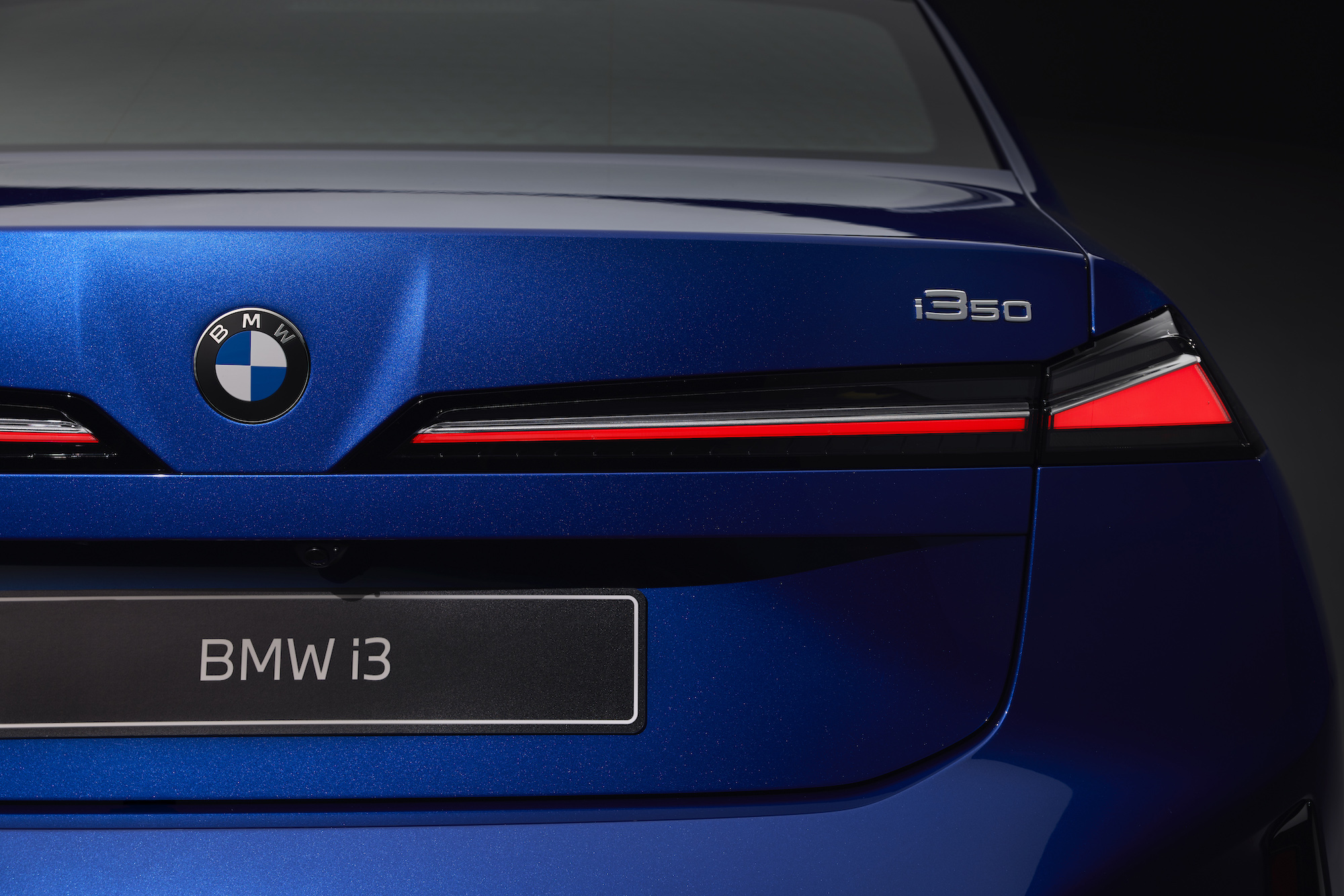 Close-up of the rear of a blue BMW i3, featuring the BMW logo, i350 badge, and distinctive taillights.