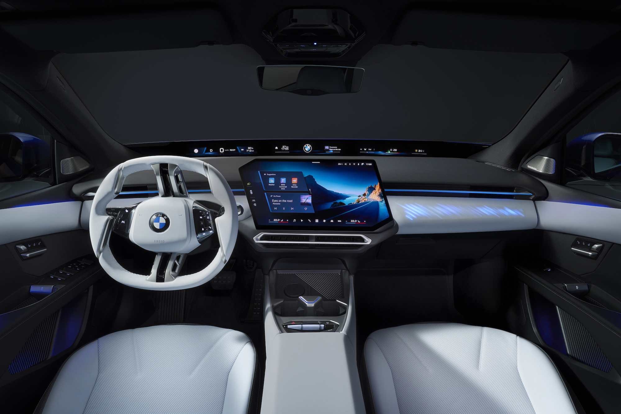 Interior view of a modern BMW vehicle, showcasing a sleek dashboard, large digital display, and a stylish steering wheel.