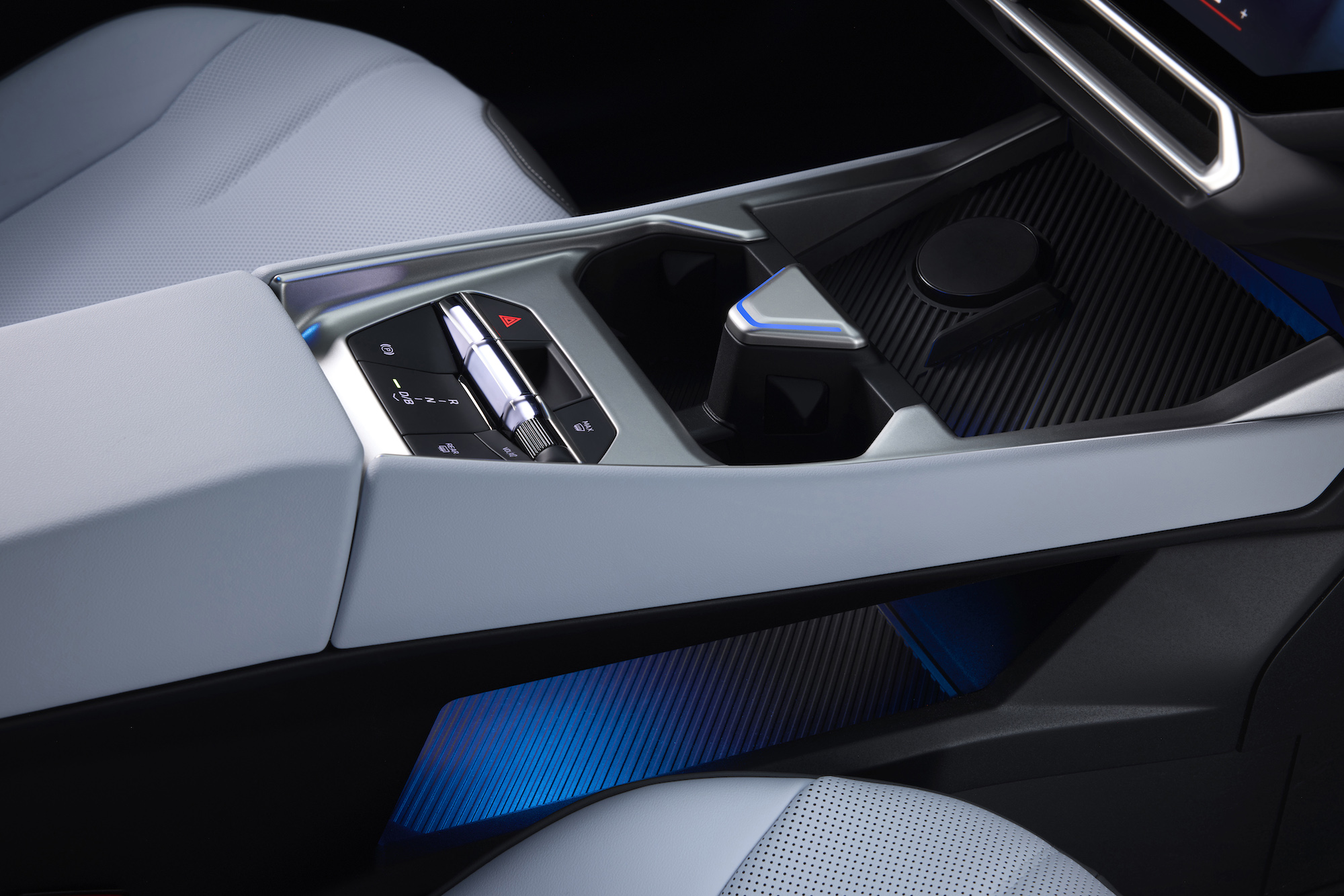 Close-up view of a modern car's center console featuring sleek controls, a gear selector, and ambient lighting.