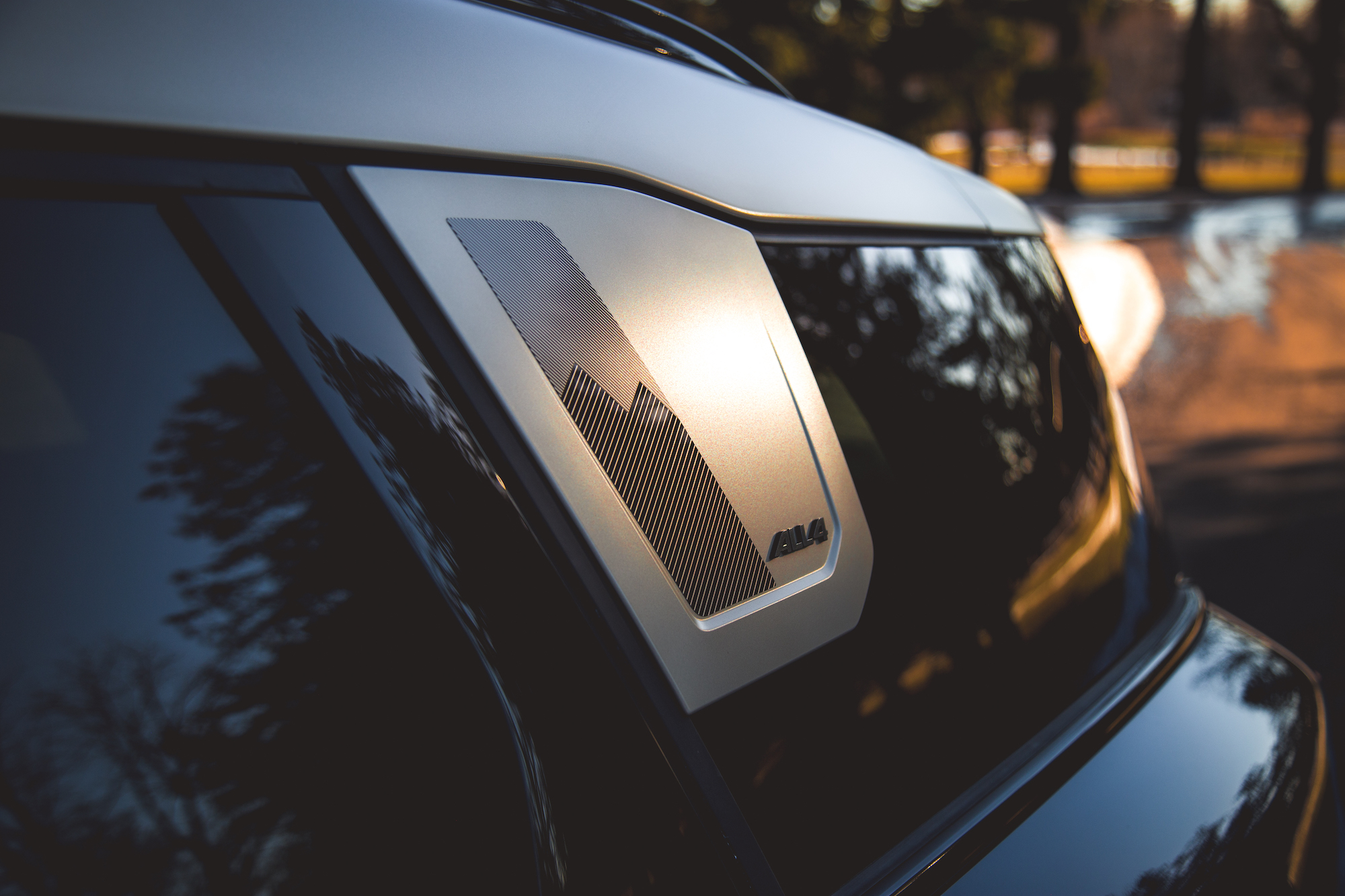 Close-up of a car's side panel showing a silver accent with a textured design and the label '4WD'.