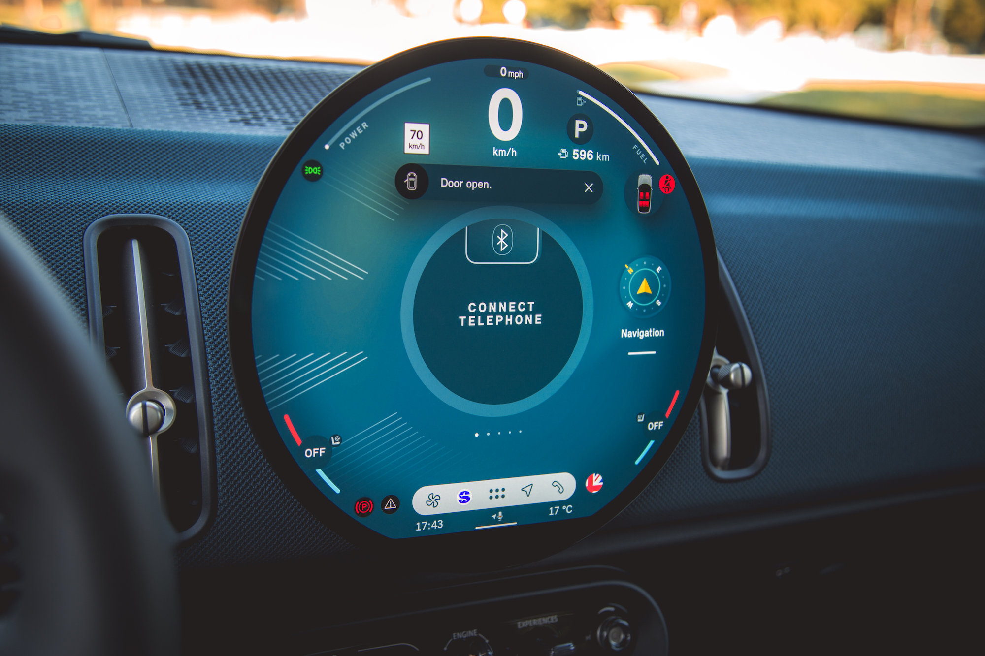 Close-up of a modern car dashboard display showing speed, fuel level, and navigation options.