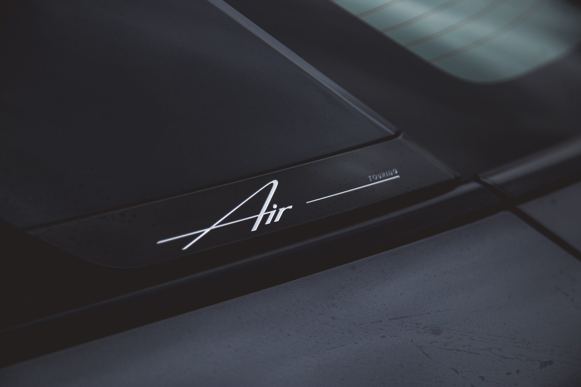 Primer plano de la parte trasera de un automóvil que muestra el estilizado emblema 