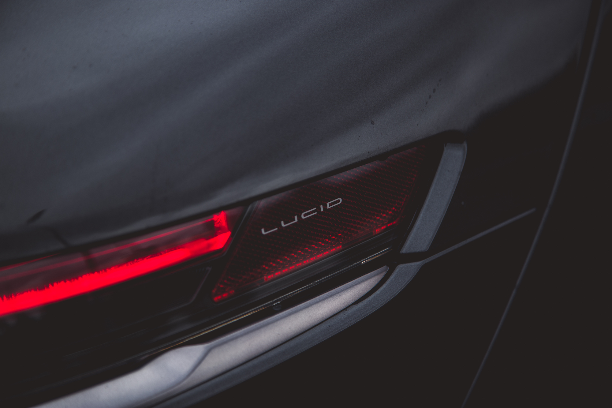 Primer plano de la luz trasera y la marca de un vehículo eléctrico Lucid.