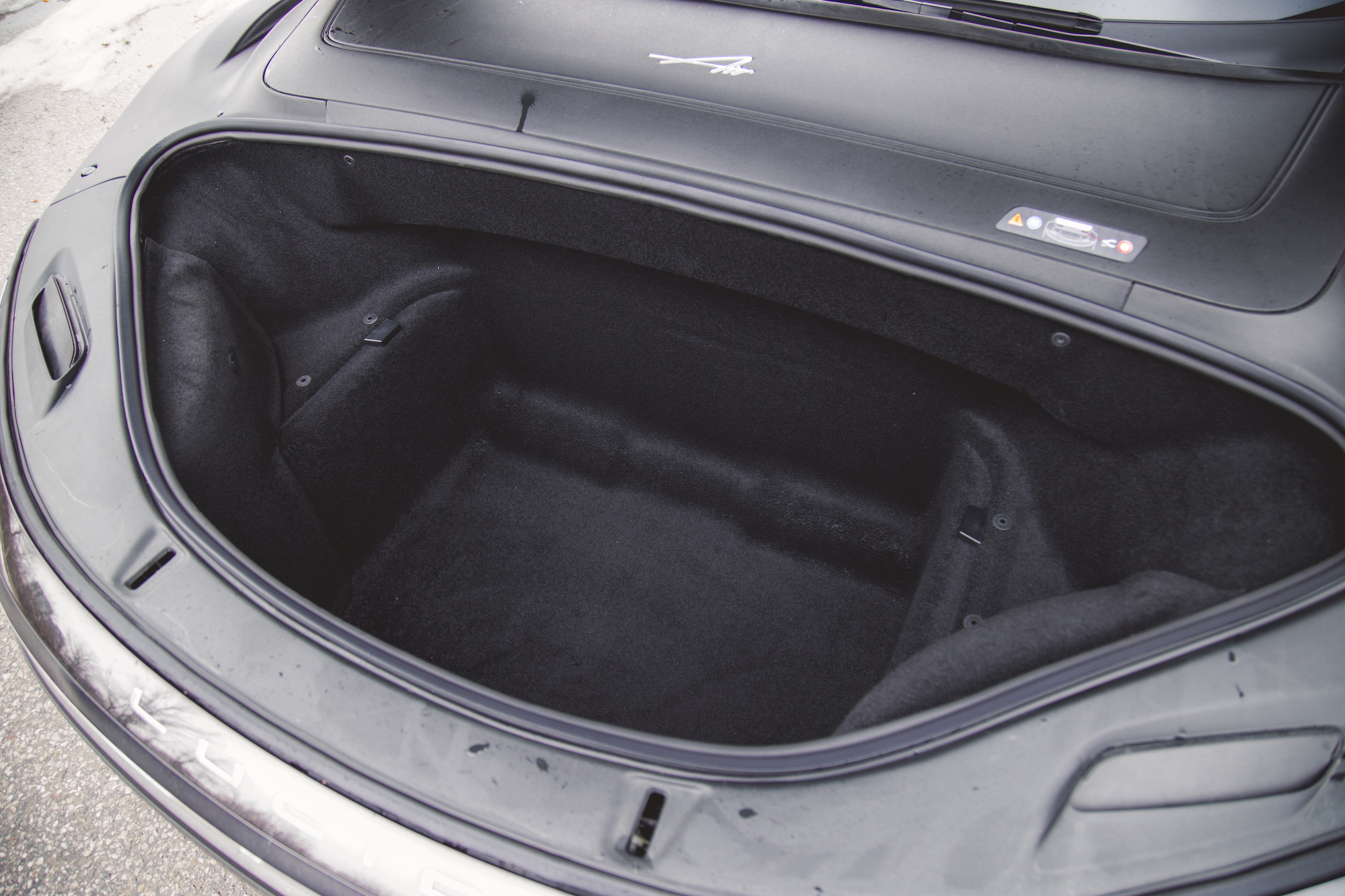 Vista del maletero espacioso y vacío dentro de un automóvil elegante, con un interior tapizado en negro.