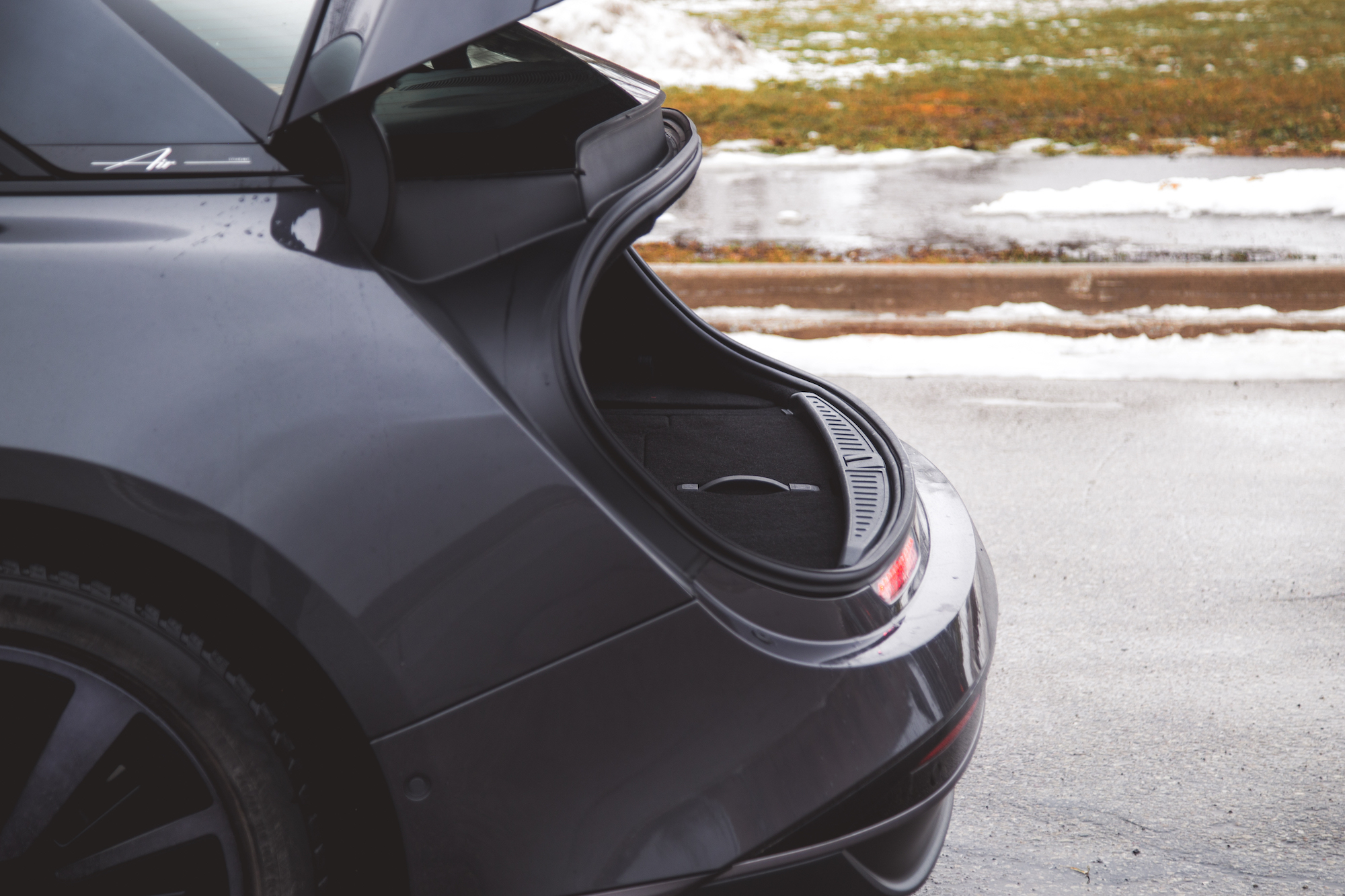 Vista de un maletero abierto de un automóvil gris, que muestra el espacioso interior y el revestimiento del maletero.