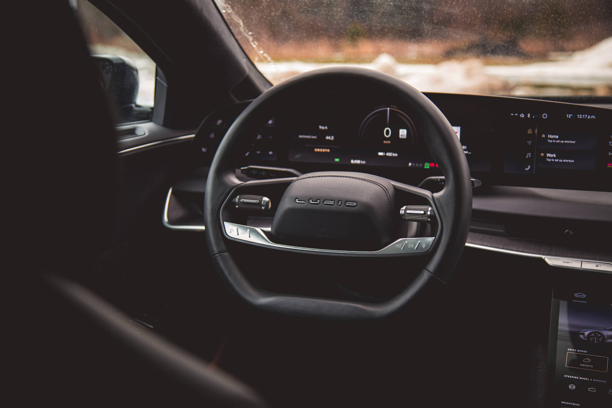 Vista interior de un automóvil eléctrico Lucid, que muestra el volante y las pantallas del tablero digital.