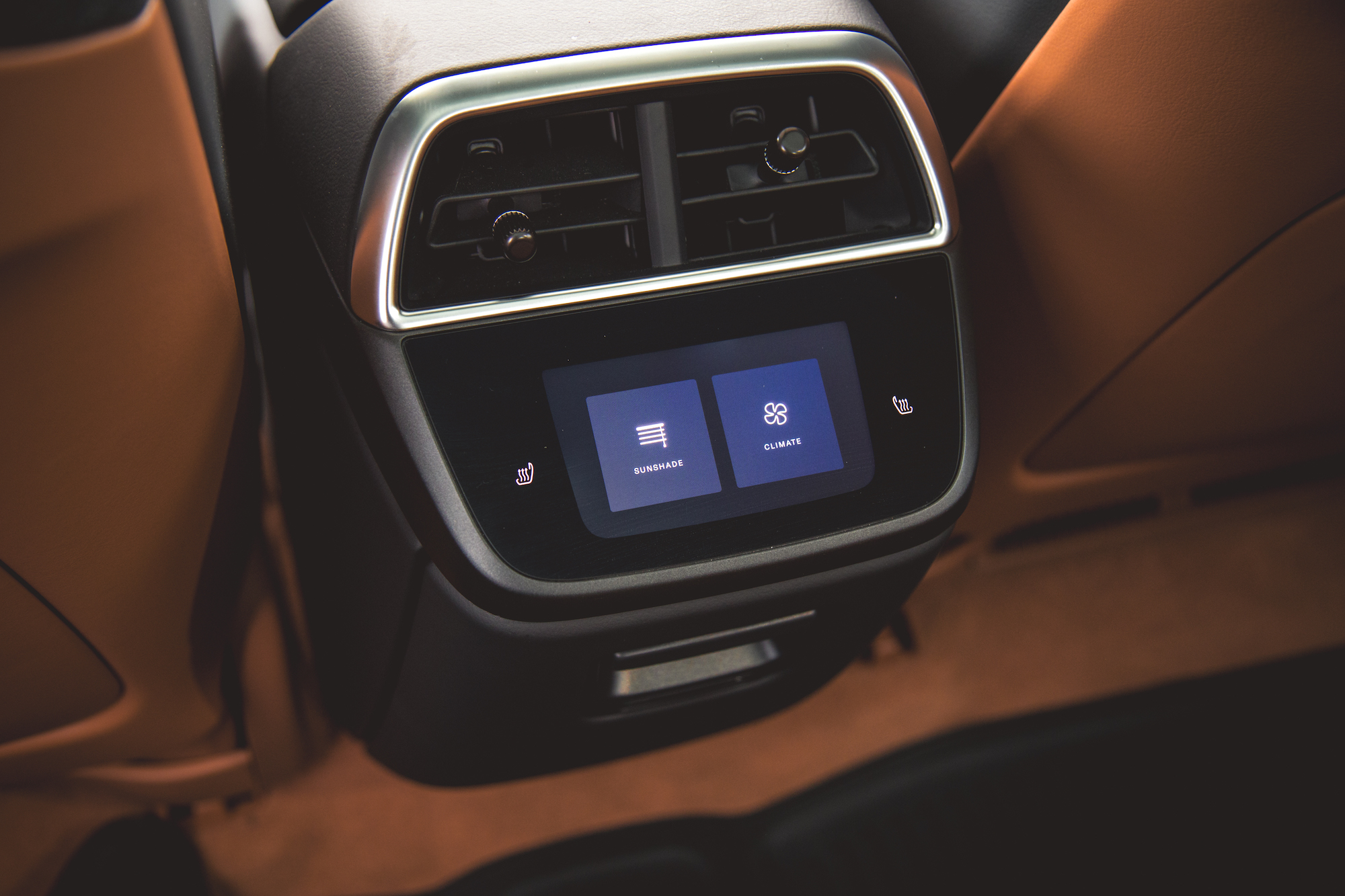 Primer plano del panel de control de un automóvil moderno con botones táctiles para la configuración del parasol y del clima, junto con controles de calefacción.