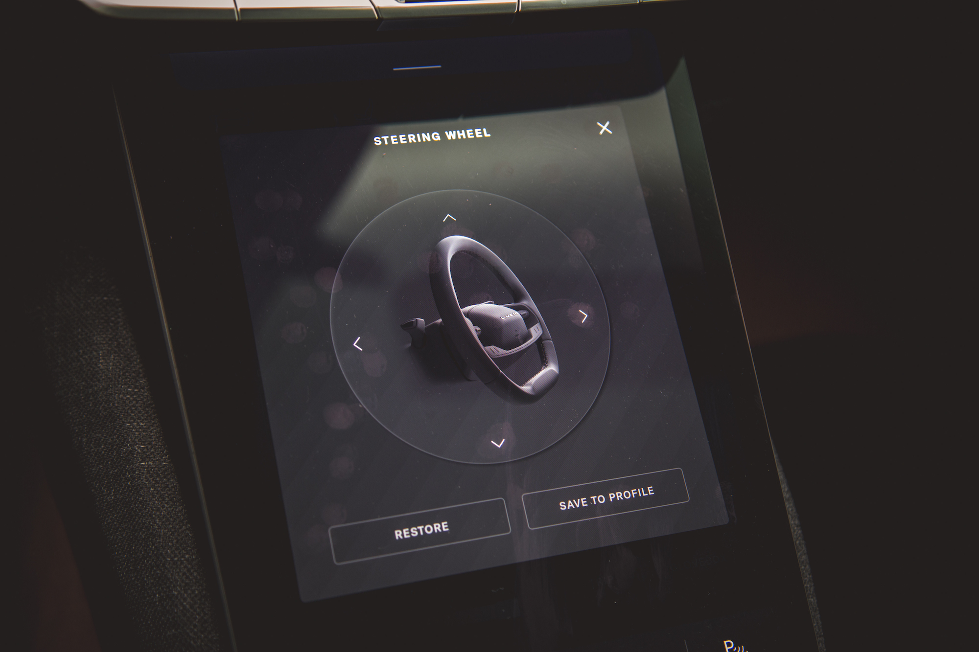 Una pantalla de interfaz digital que muestra un volante con flechas direccionales y botones etiquetados como 