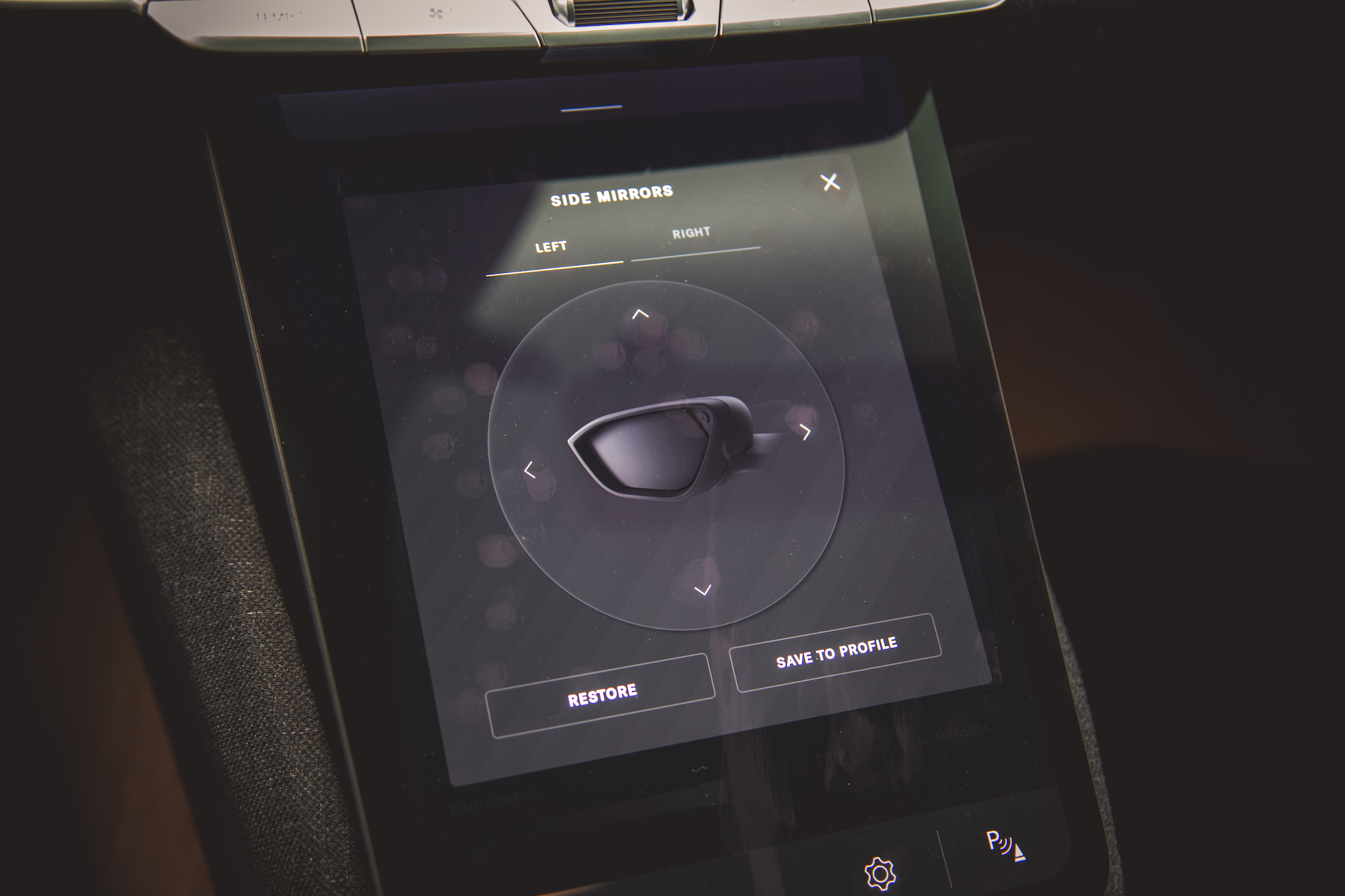Un primer plano de la interfaz de pantalla táctil de un automóvil que muestra las opciones de ajuste de los espejos laterales etiquetadas como 