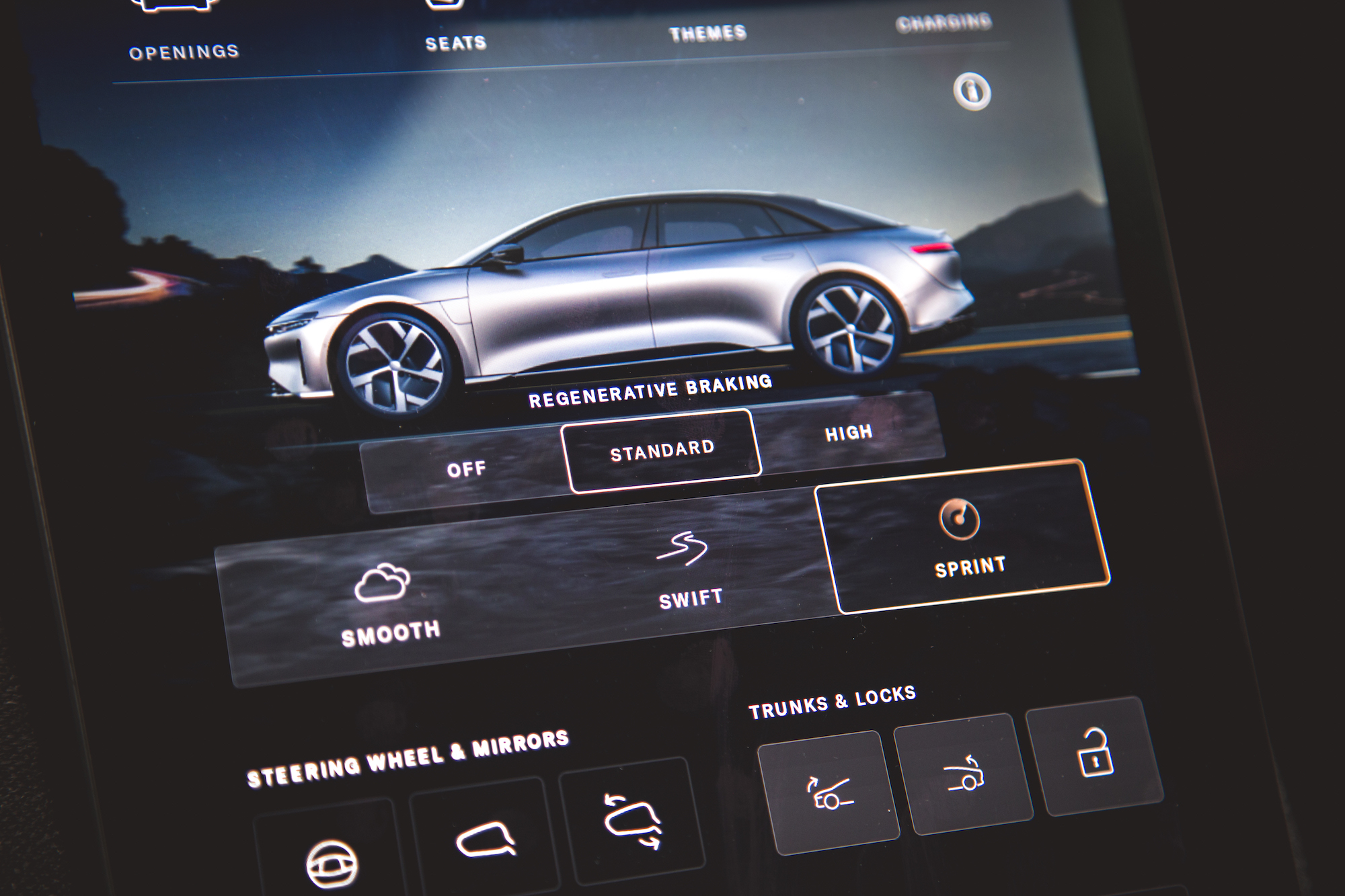 Primer plano de la interfaz del tablero de un automóvil que muestra opciones para frenado regenerativo y modos de conducción, incluidos apagado, estándar, alto, suave, rápido y sprint.
