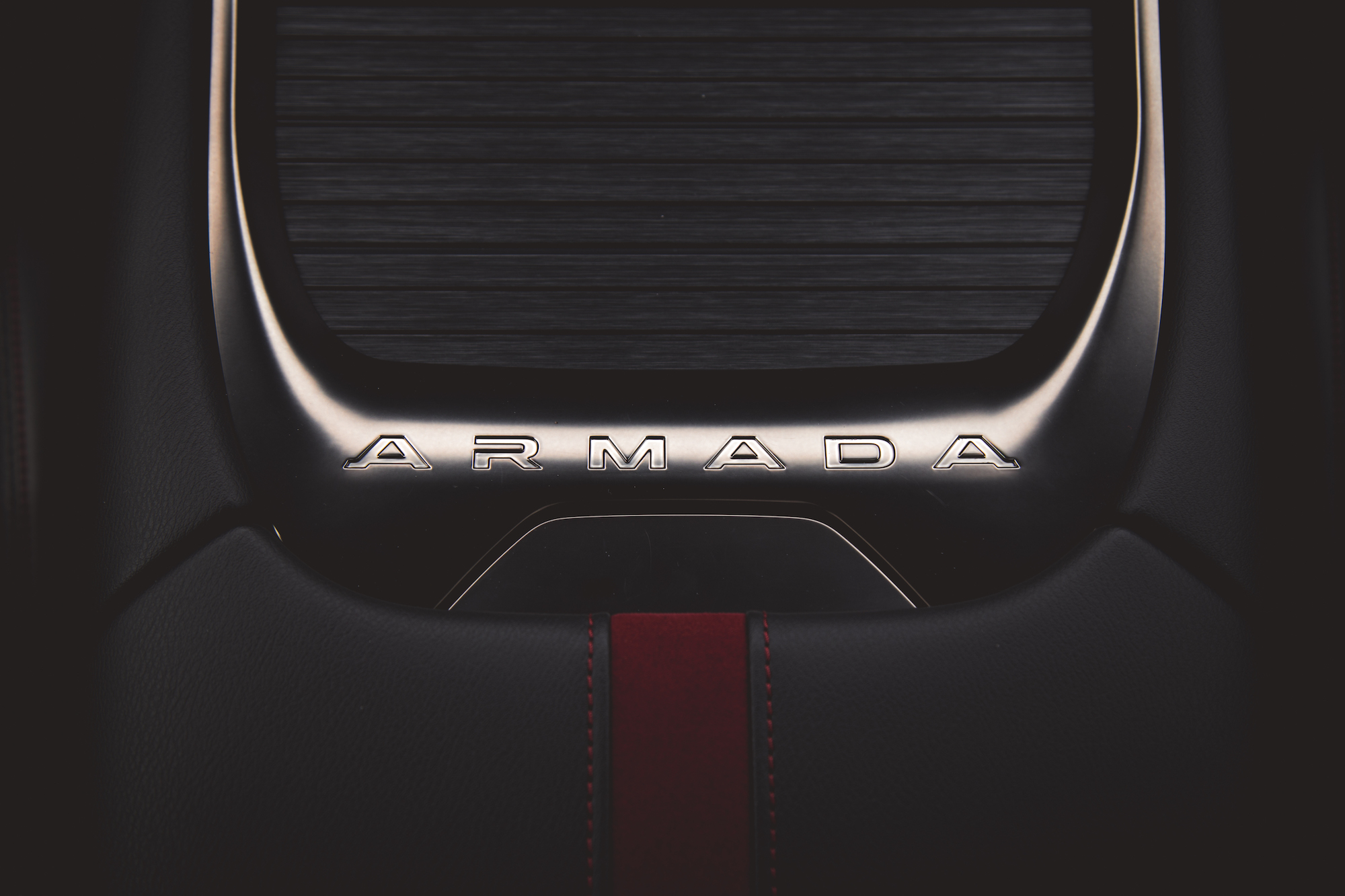 Primer plano del interior de un automóvil con el emblema 'ARMADA' en una elegante superficie del tablero.