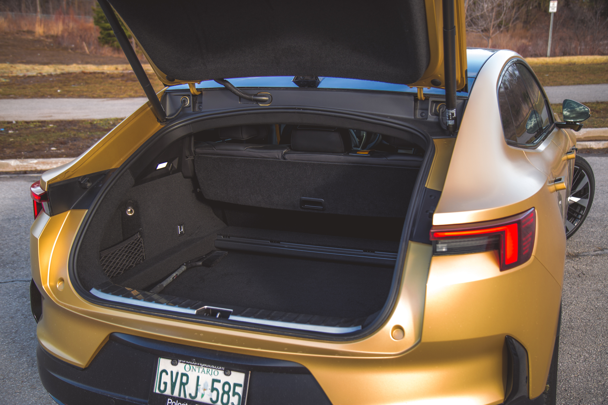 Vista del área del maletero de un automóvil con la escotilla abierta, que muestra el espacioso compartimiento de almacenamiento y el revestimiento interior.