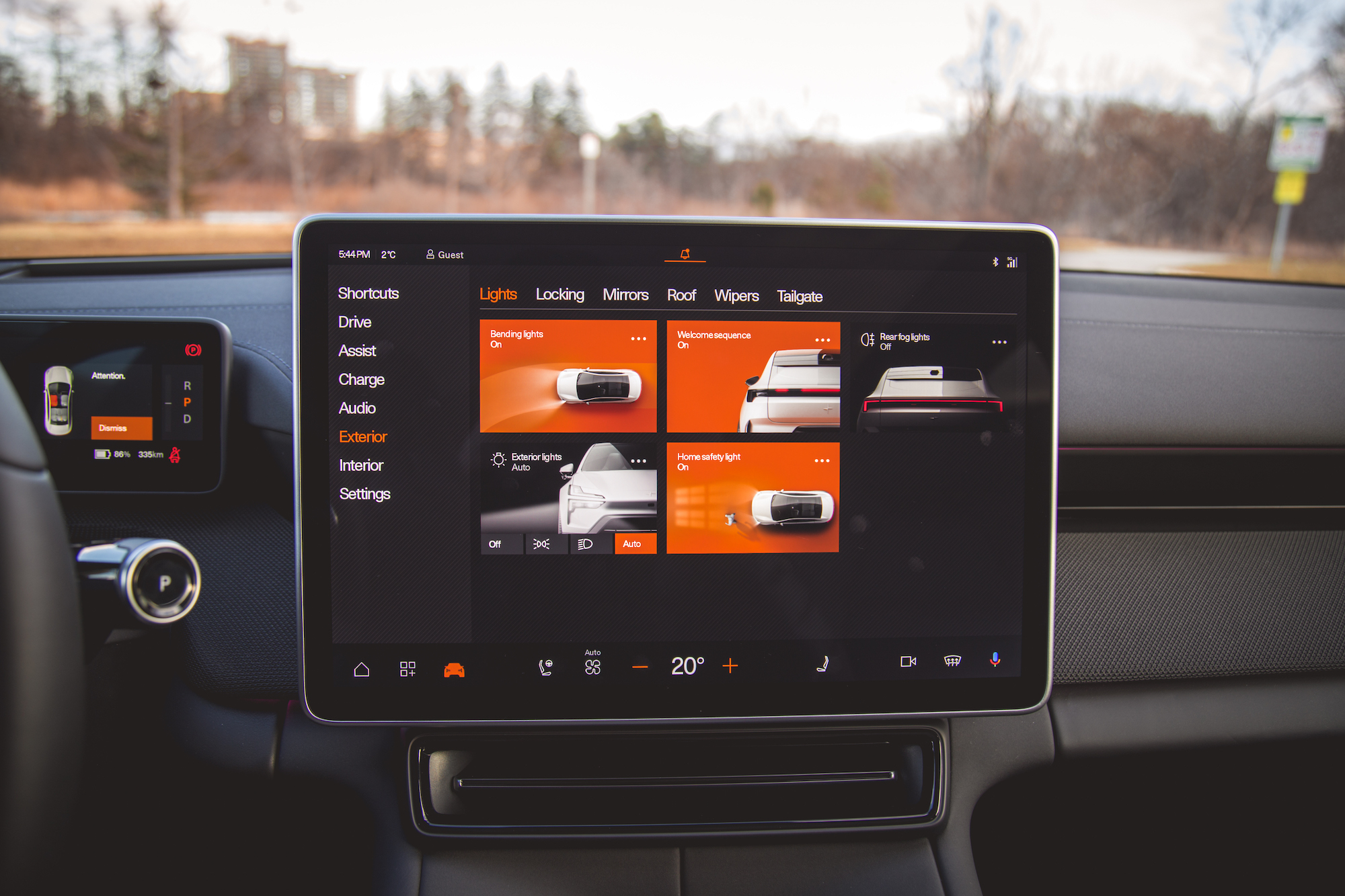 Vista interior de un automóvil moderno que muestra un tablero con pantalla táctil con varias configuraciones para luces, cerraduras y otras funciones.