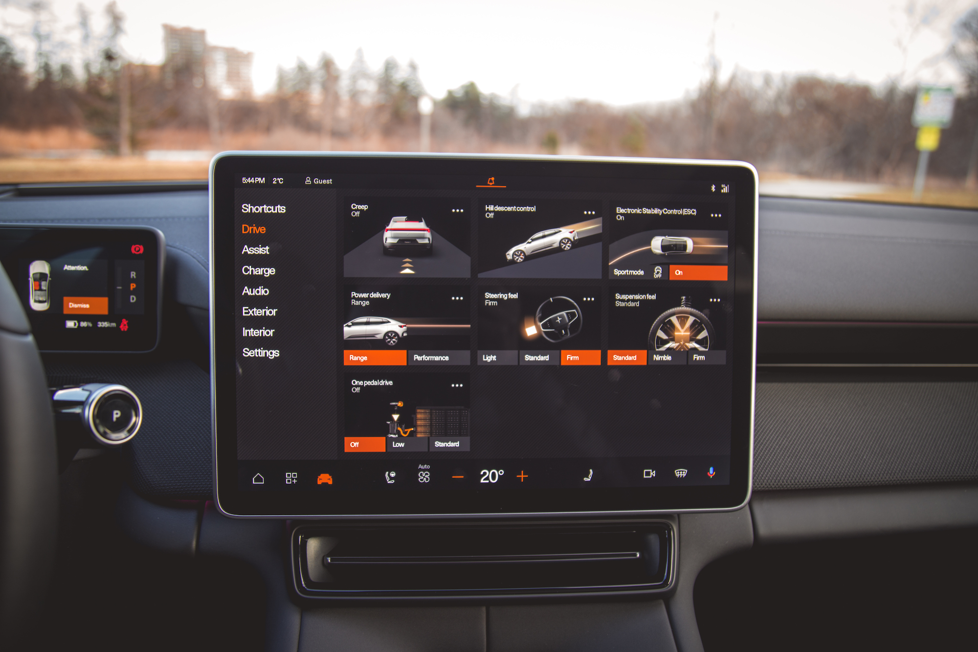 Vista en primer plano de la pantalla táctil de un automóvil moderno que muestra varias configuraciones, incluidos modos de conducción, opciones de audio y características de rendimiento del vehículo.