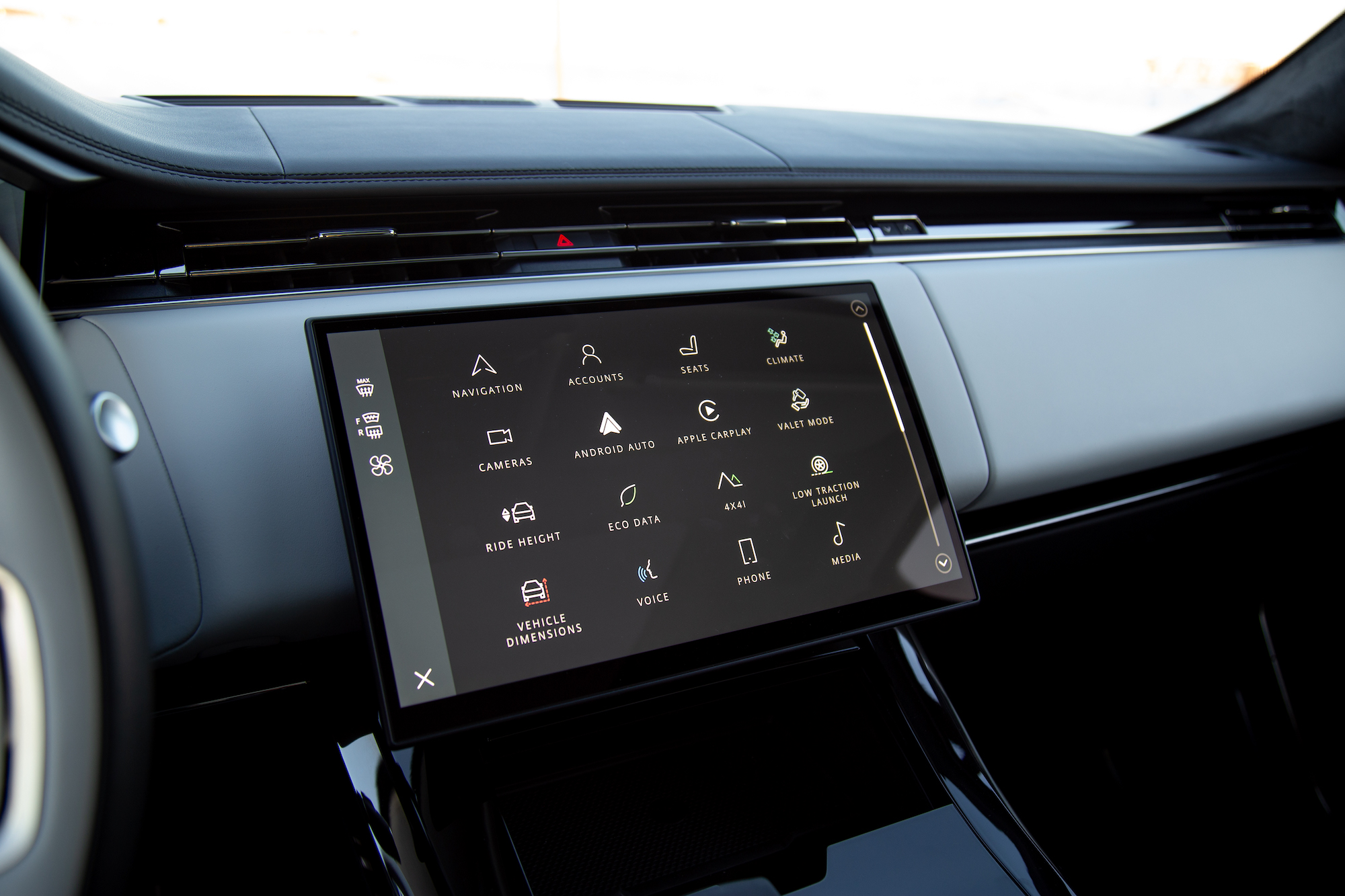 Close-up view of a modern car dashboard featuring a large touchscreen interface displaying various vehicle settings and options, including navigation, climate control, and media.