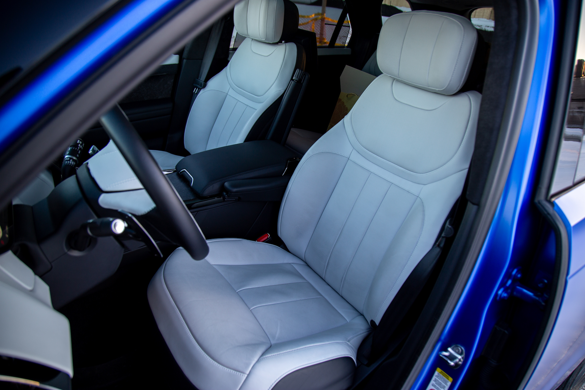 Interior view of a car featuring two premium, light-colored leather front seats with modern design.