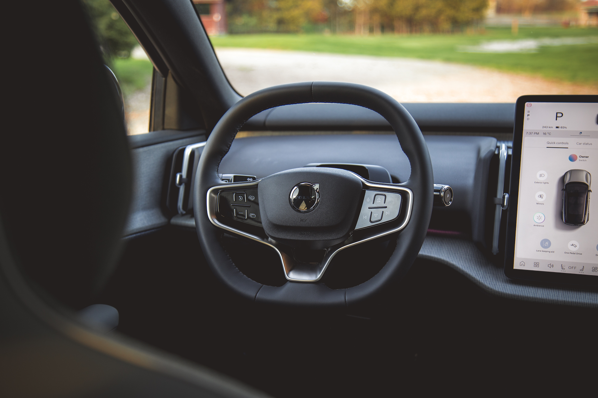 Vista interior de un automóvil que muestra el volante y el panel de visualización digital.