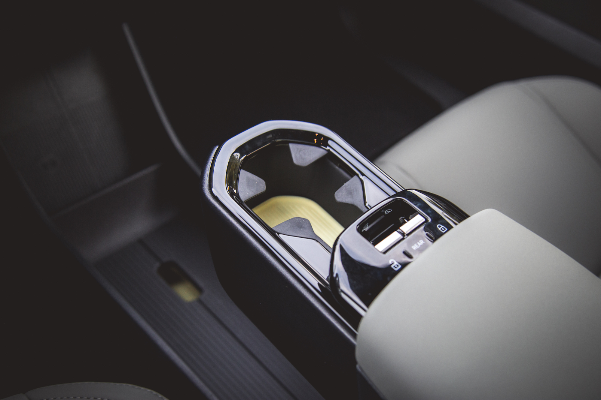 Primer plano de la consola central de un automóvil con un diseño elegante, adornos metálicos y botones de control.