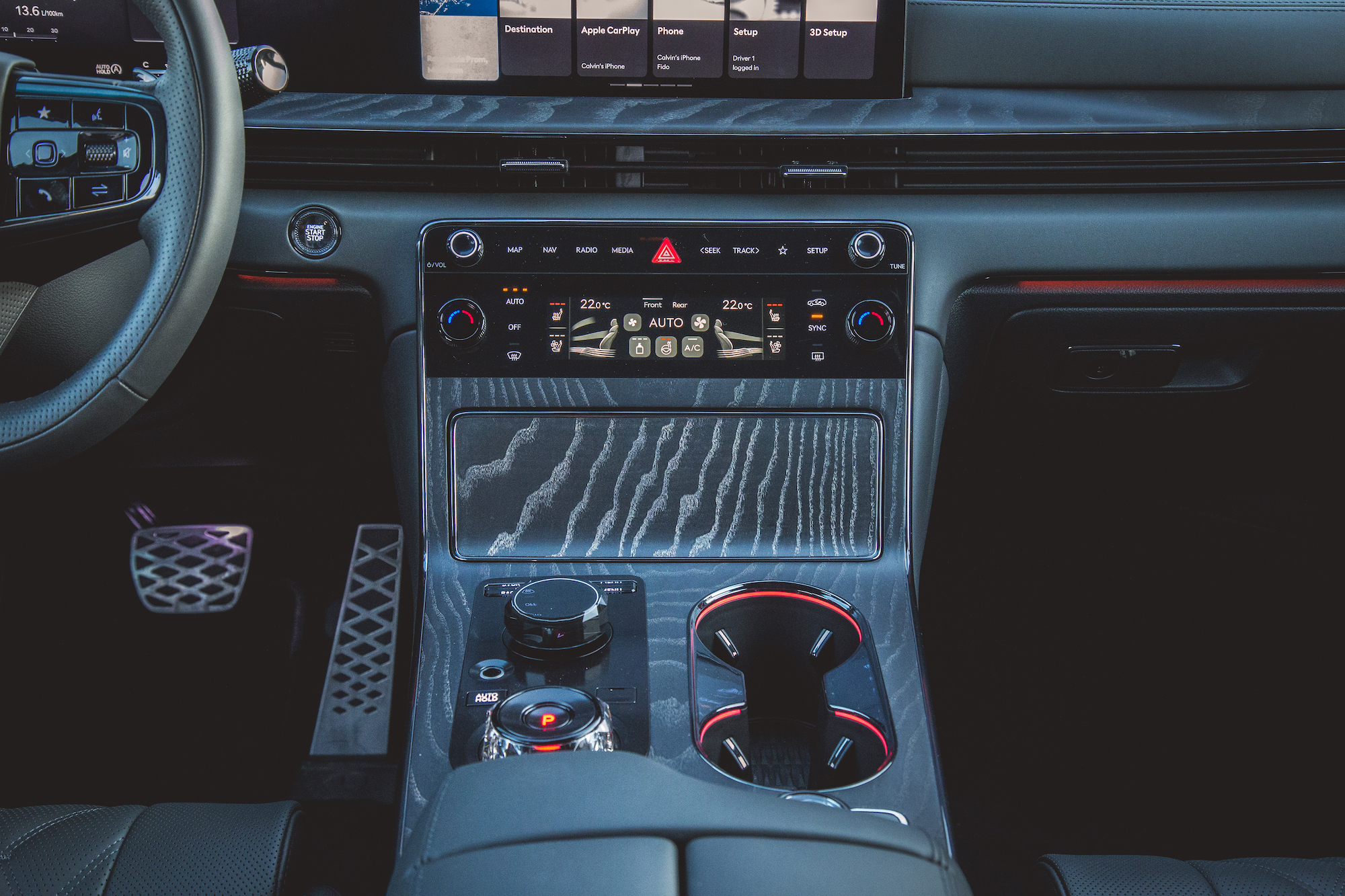 Interior view of a modern car's center console featuring a touch screen display, climate controls, and metallic accents.