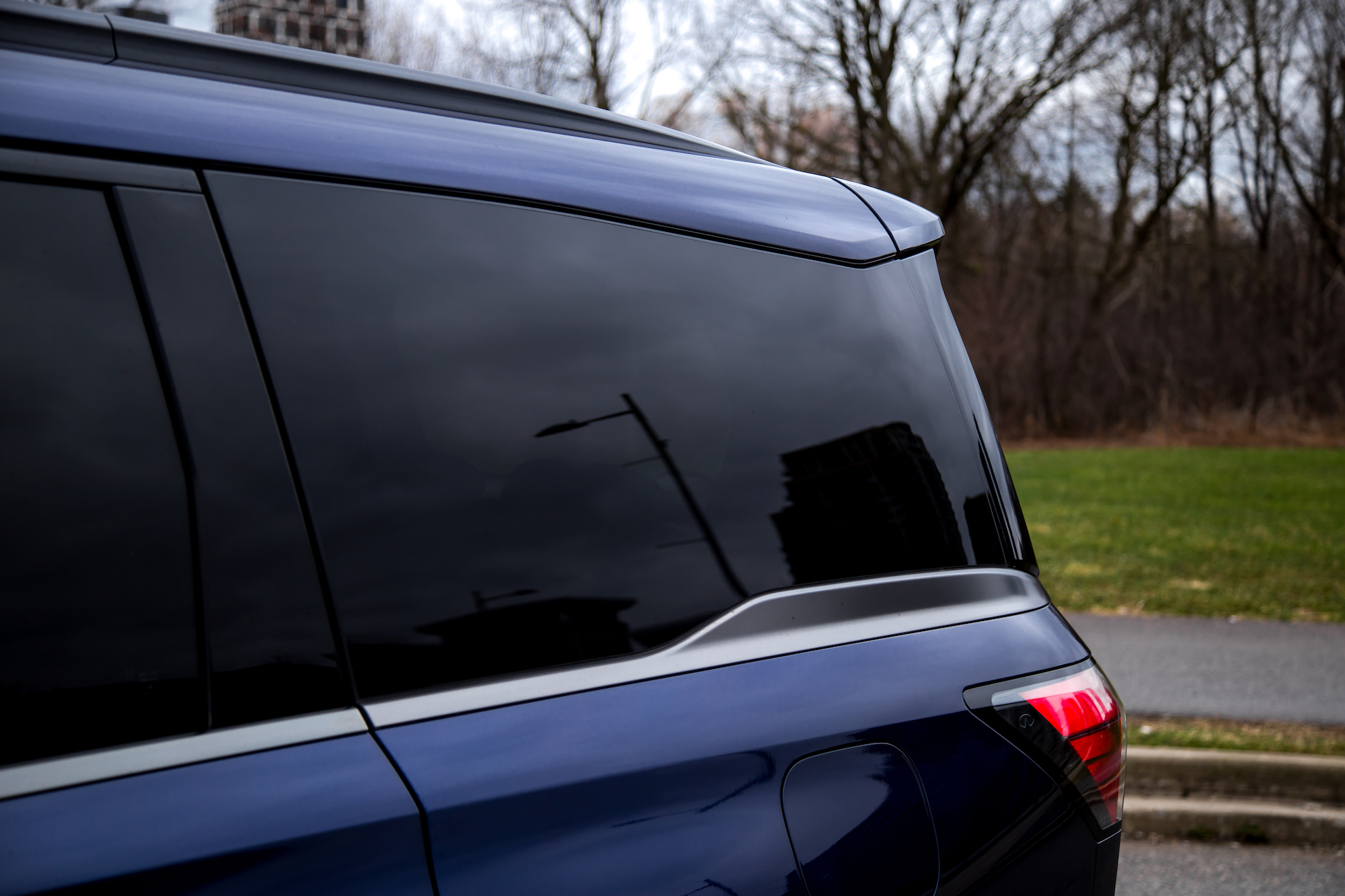 Primer plano de la parte trasera de un vehículo azul oscuro con cristales tintados y un diseño aerodinámico.