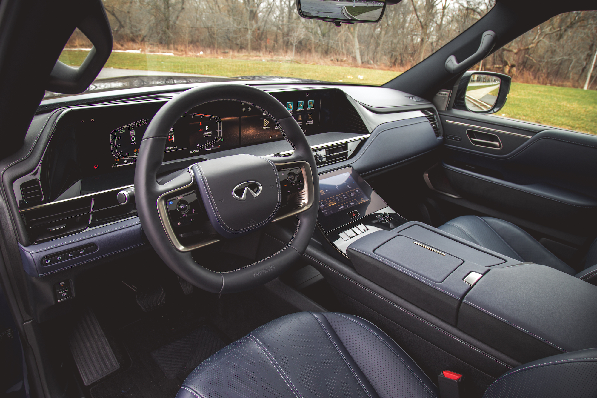 Vista interior de un automóvil de lujo que muestra el tablero, el volante y los asientos, con un diseño moderno y pantalla digital avanzada.