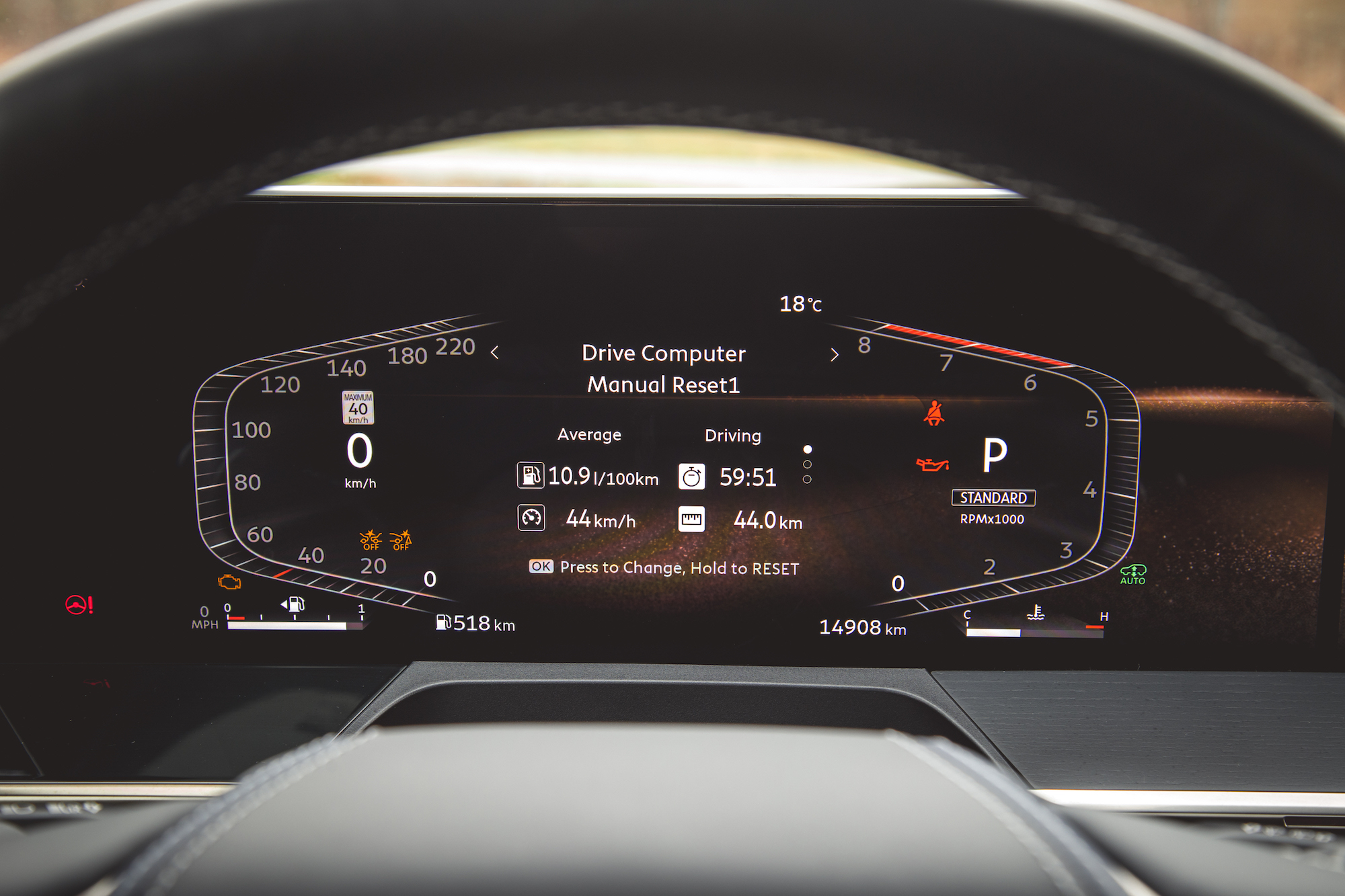 Una vista de primer plano de la pantalla del tablero digital de un automóvil, que muestra la información de la computadora del manejo, incluido el consumo promedio de combustible, la velocidad actual, el tiempo de conducción y la distancia recorrida.