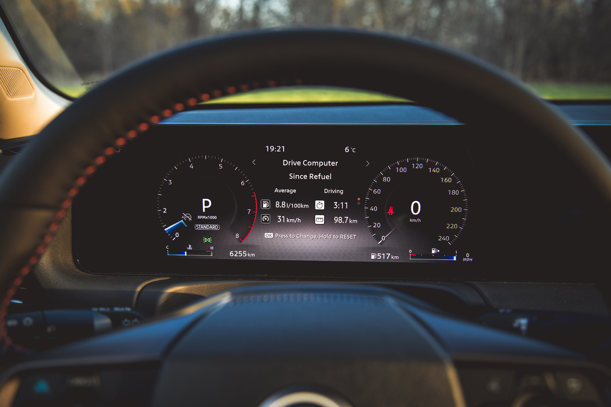 Vista interior del tablero de un automóvil que muestra la computadora de manejo con estadísticas como el consumo promedio de combustible, el tiempo de conducción y la velocidad. La marcha está en posición de estacionamiento (P) con una temperatura actual de 6°C.