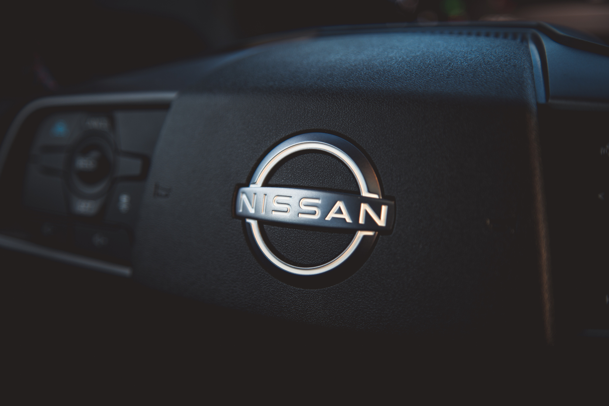 Primer plano de un emblema de Nissan en el tablero de un automóvil.