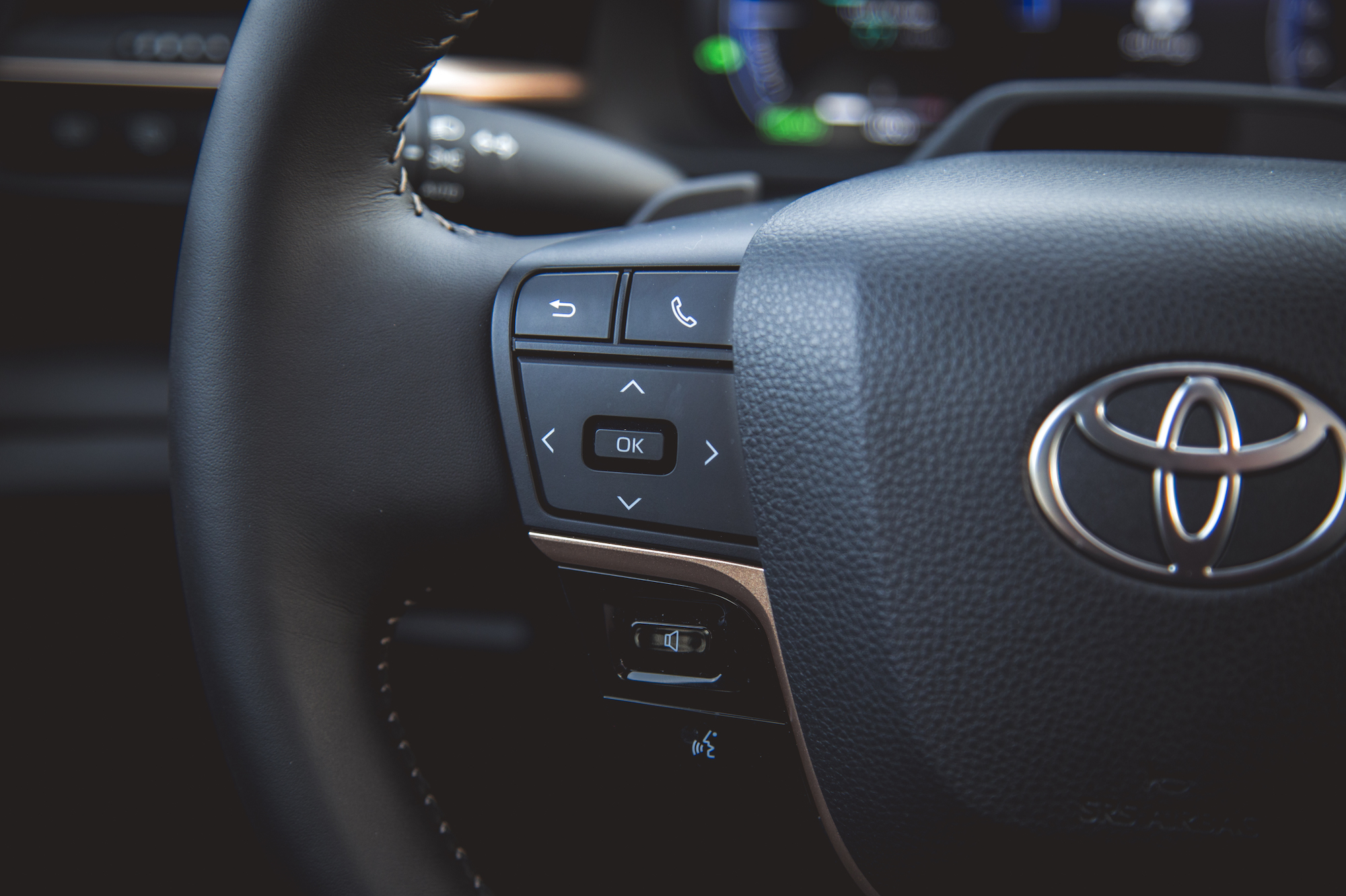 Primer plano de un volante Toyota con botones de control para configuración de teléfono, navegación y audio.