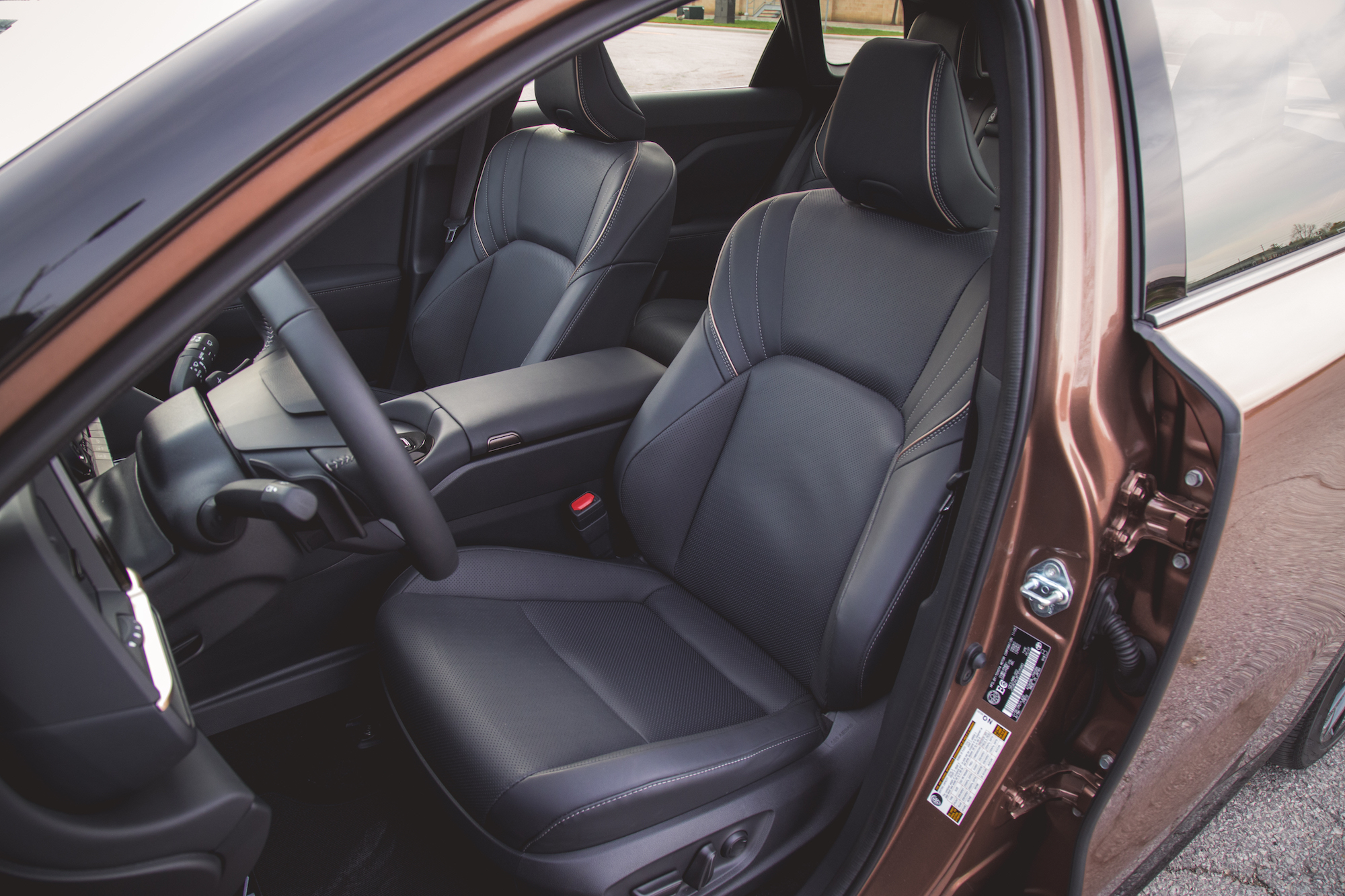 Vista interior de un automóvil que muestra asientos de cuero negro, un volante y un tablero elegante.